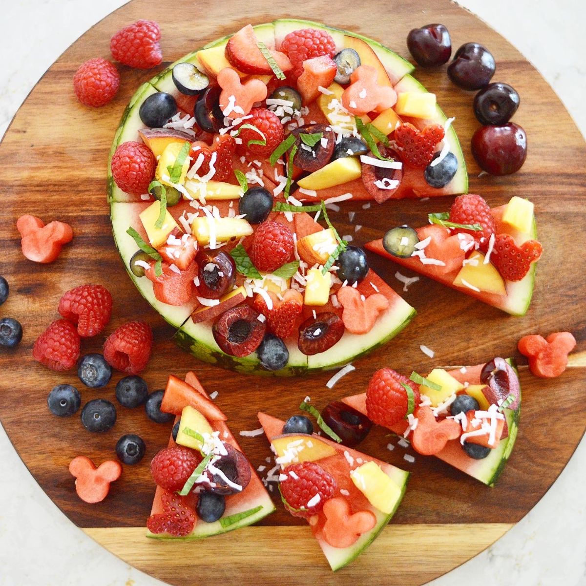 Watermelon Pizza is the most refreshing treat on a hot summer day.  Topped with a variety of fresh fruit, toasted coconut and mint.  