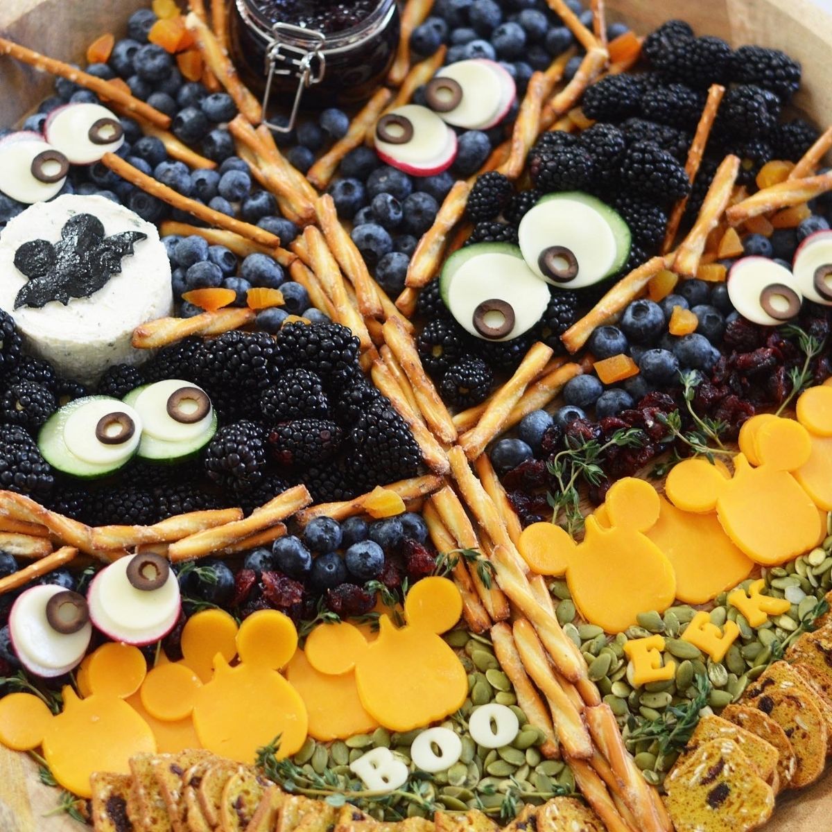 This Halloween Cheese Board is made with a spooky pretzel tree, a berry night sky and your very own Mickey pumpkin patch.  