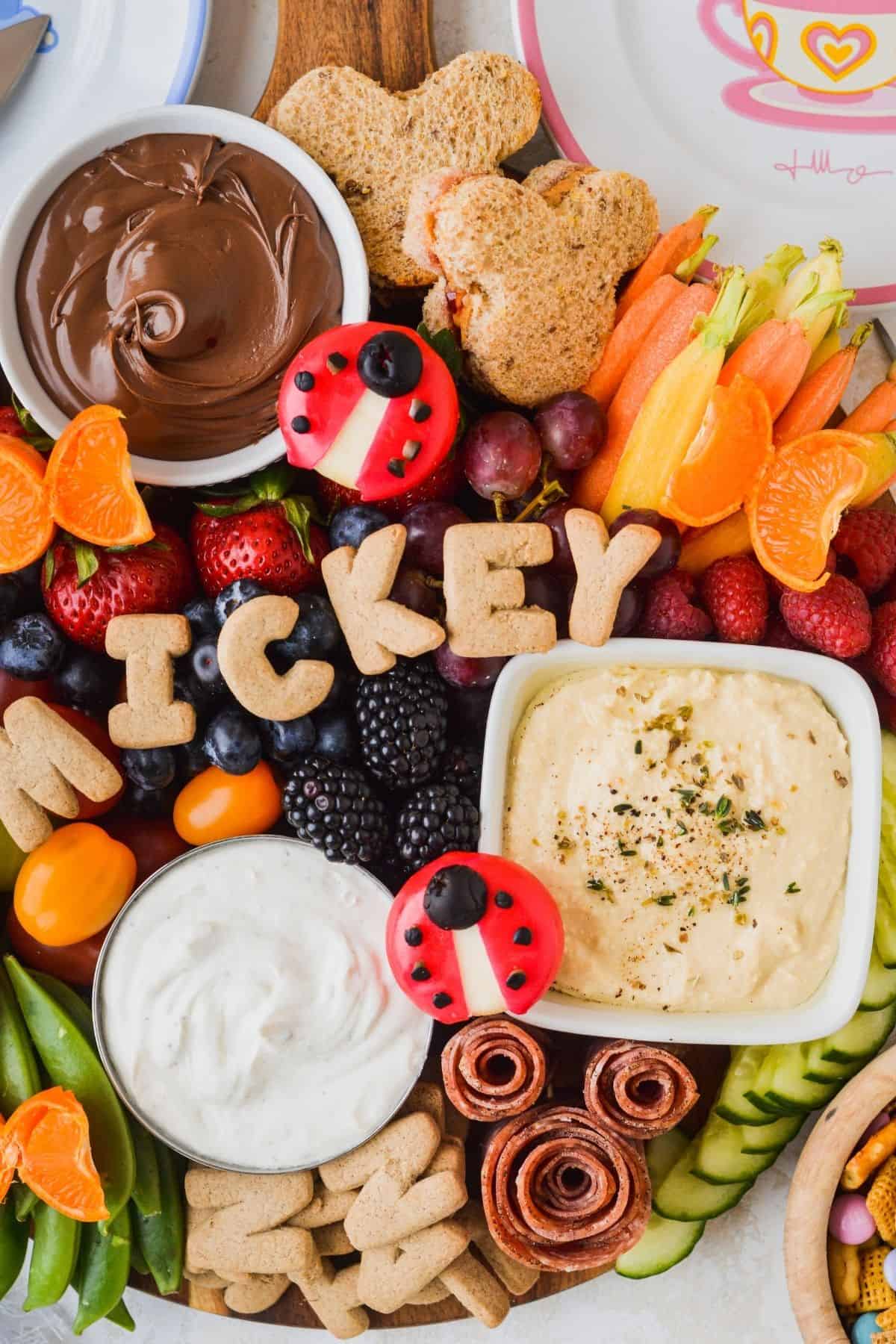 This kids charcuterie board has several dips including ranch and hummus.