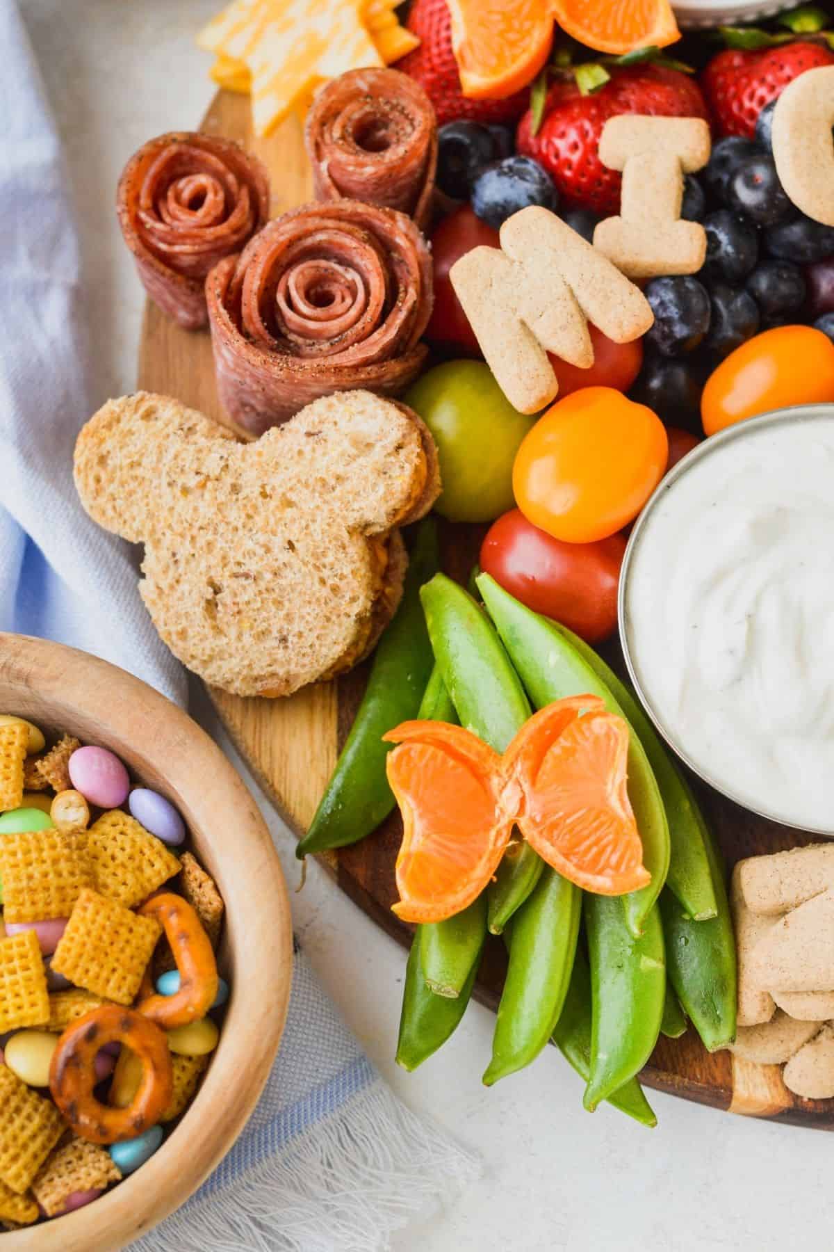 Mandarin orange butterflies with sugar snap peas, cherry tomatoes and Mickey shaped salami rosettes.