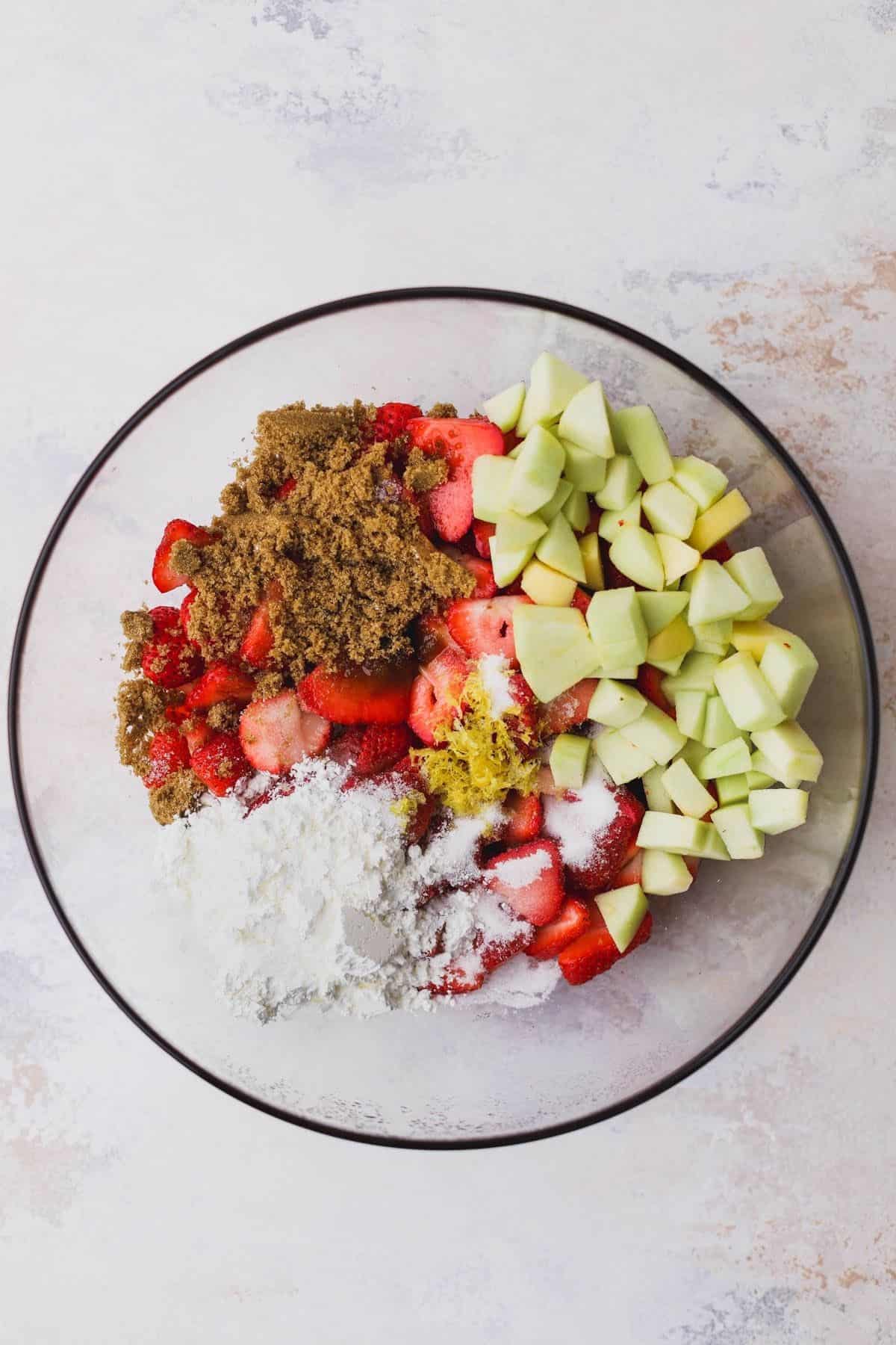 Strawberries, apples, flour, brown sugar, cinnamon, lemon zest, sugar.