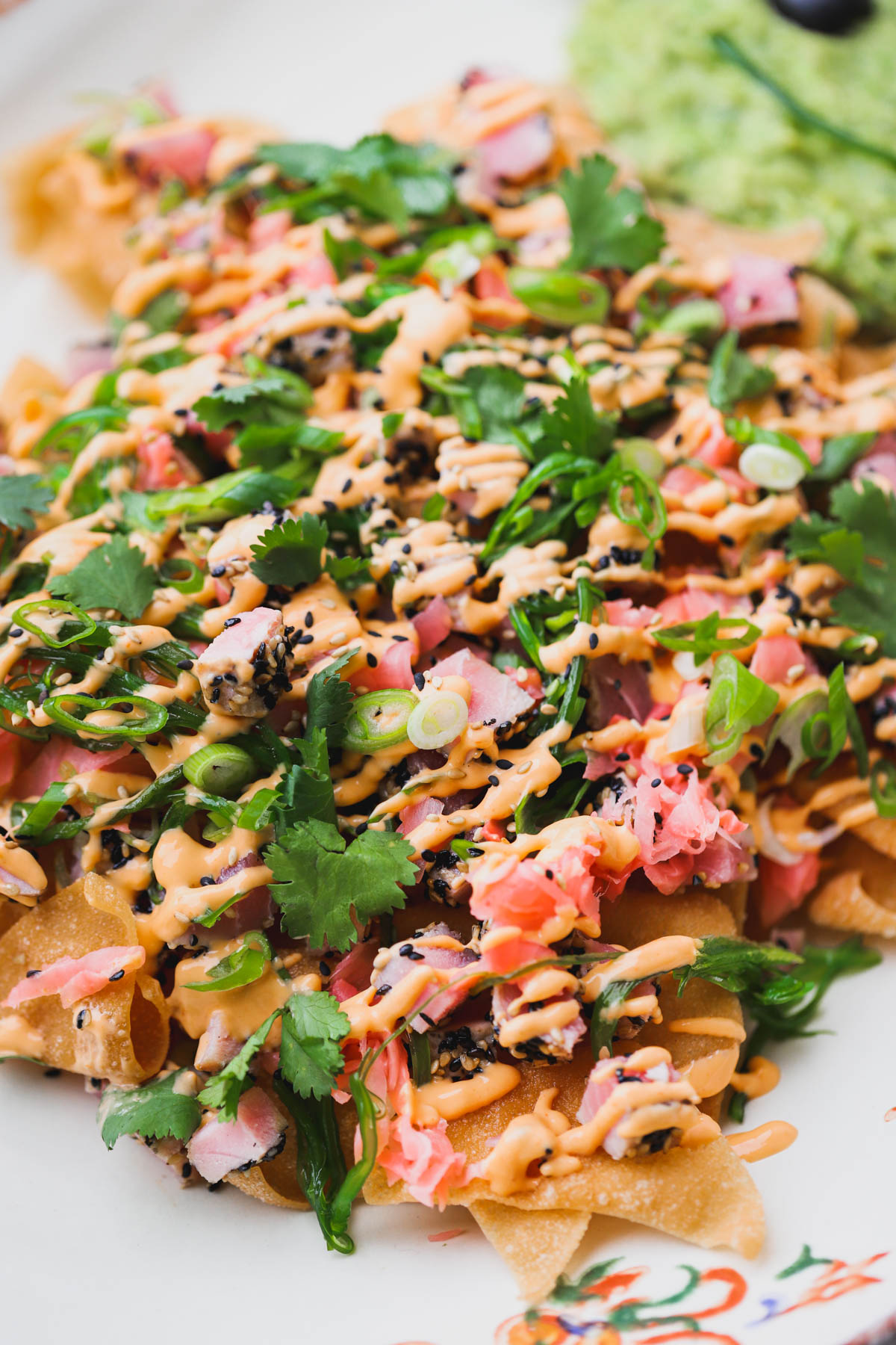 Sesame crusted Ahi Tuna nachos topped with pickled ginger, cilantro, spicy mayo, scallions and seaweed salad.  