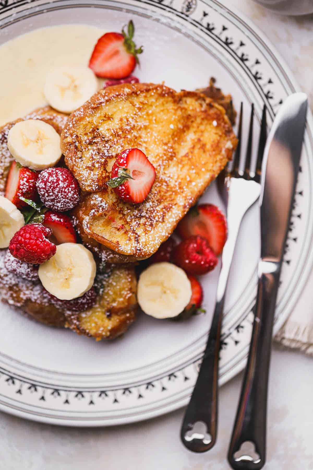 Custard French toast served with fresh berries and sliced bananas.