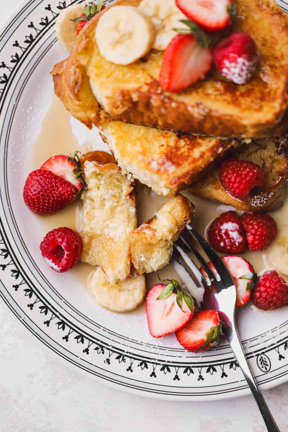 Custard French toast drizzled with maple syrup, vanilla custard and loads of berries.
