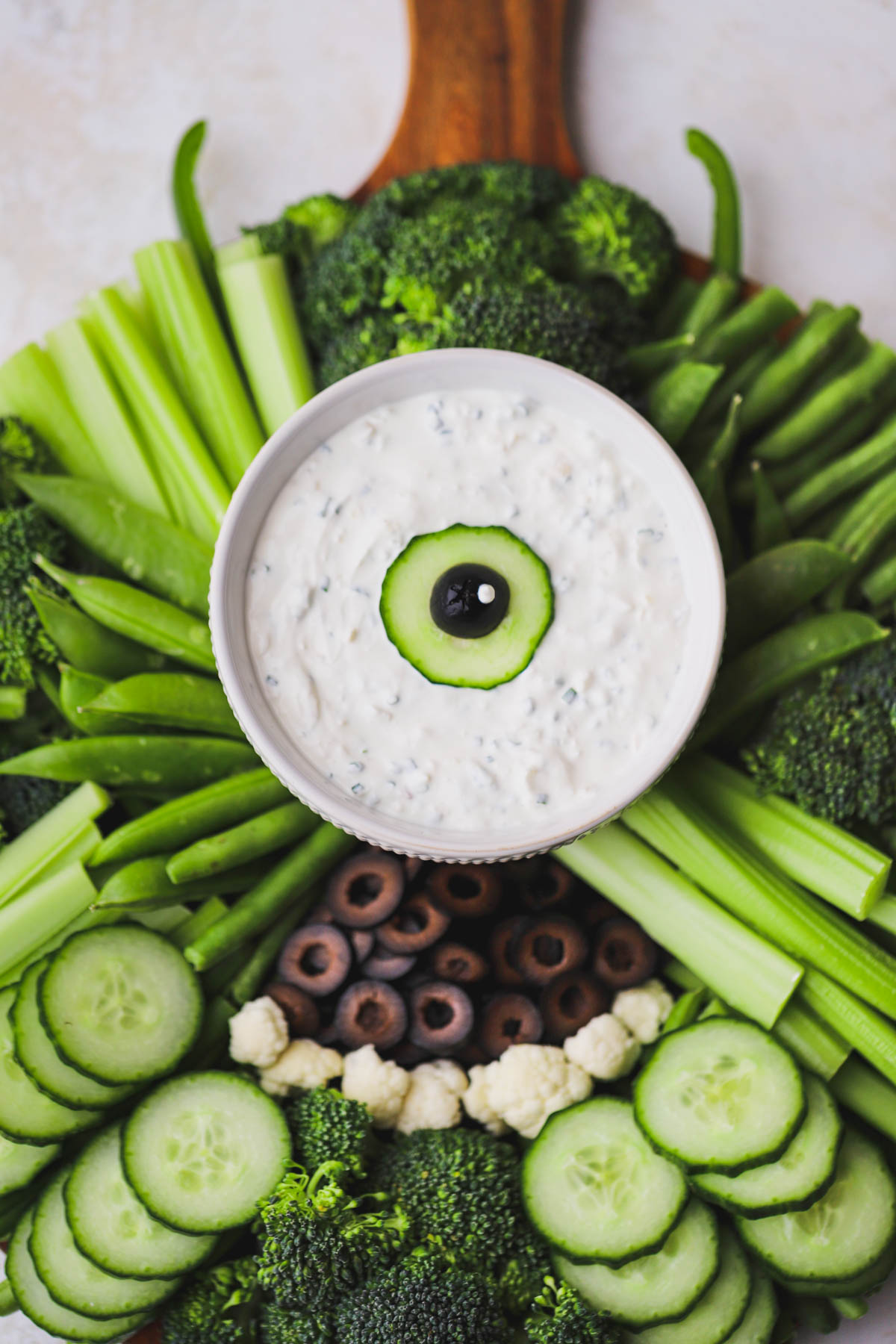 Sour cream and chive dip served alongside cucumbers, broccoli, celery, green beans and a Mike Wazowski inspired mouth.  