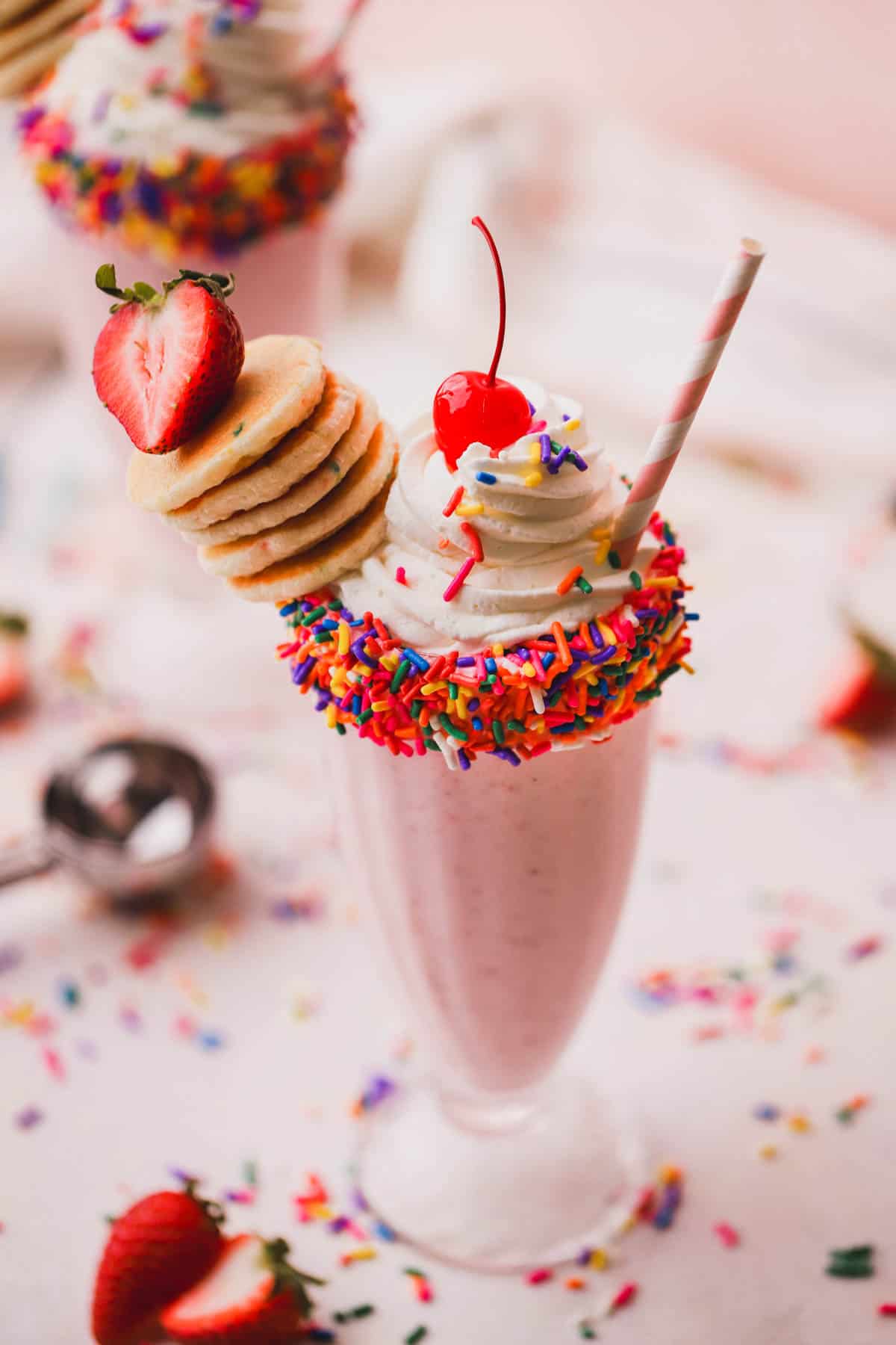 Strawberry milkshake with bananas, funfetti pancakes, whipped cream and maraschino cherry.