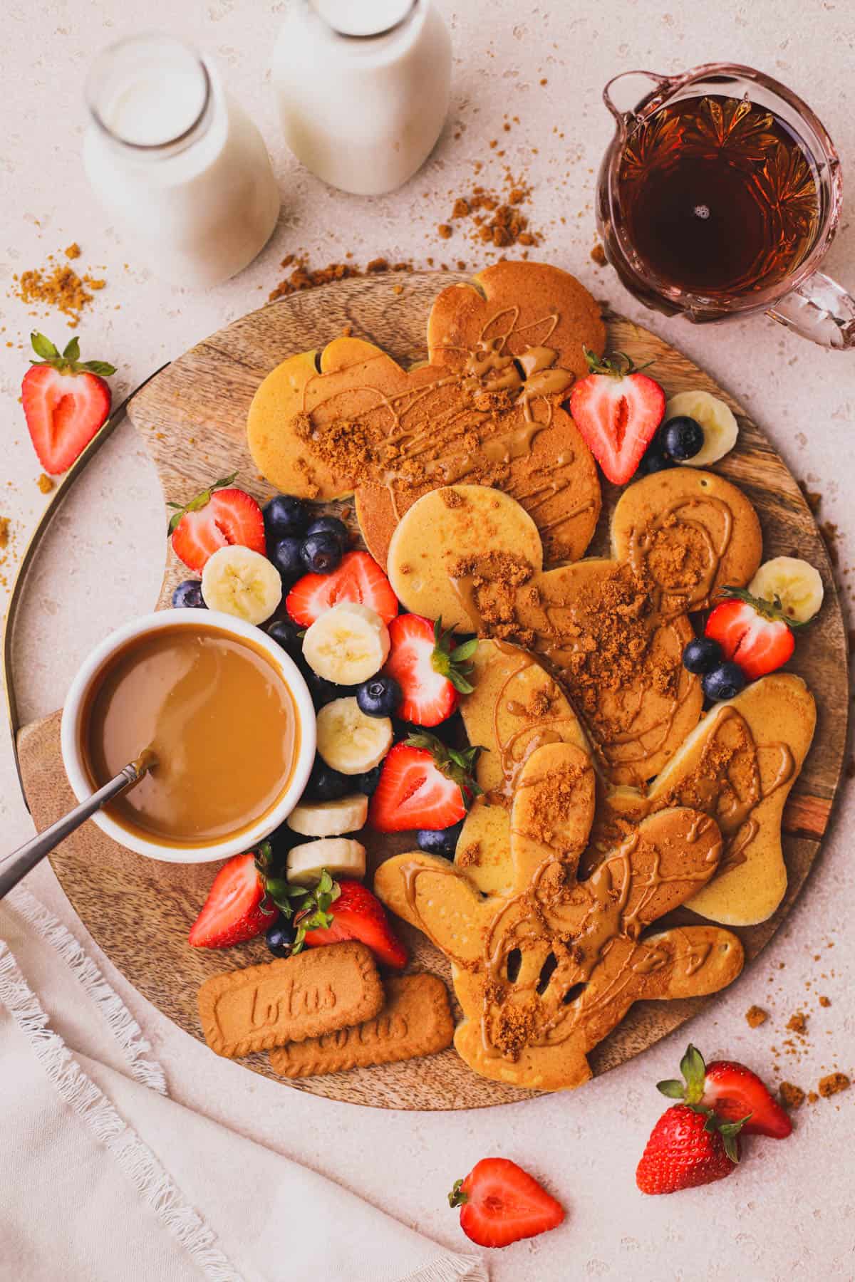 Mickey shaped Biscoff pancakes with fresh fruit, crushed cookies and syrup.