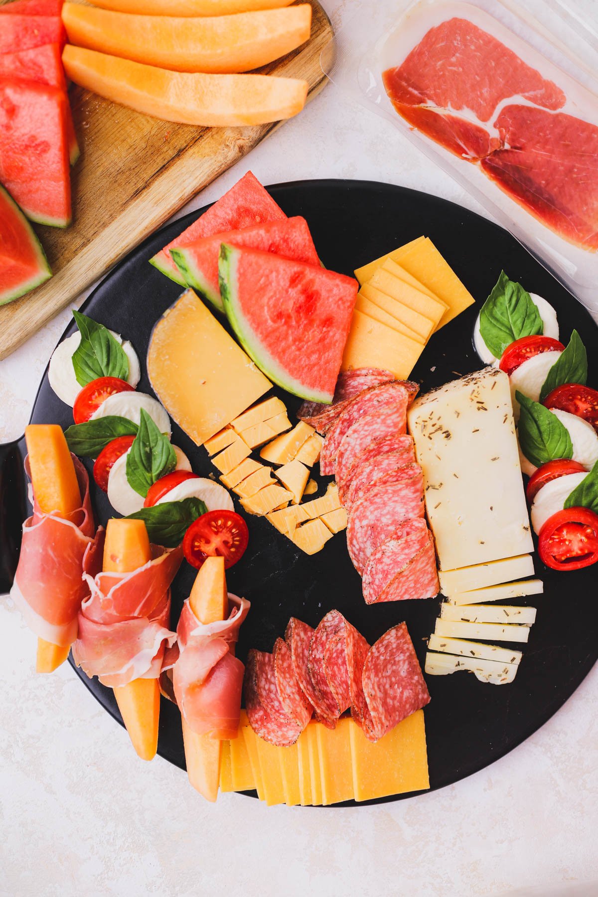 Cheese, salami, prosciutto wrapped cantaloupe, watermelon and caprese salad.