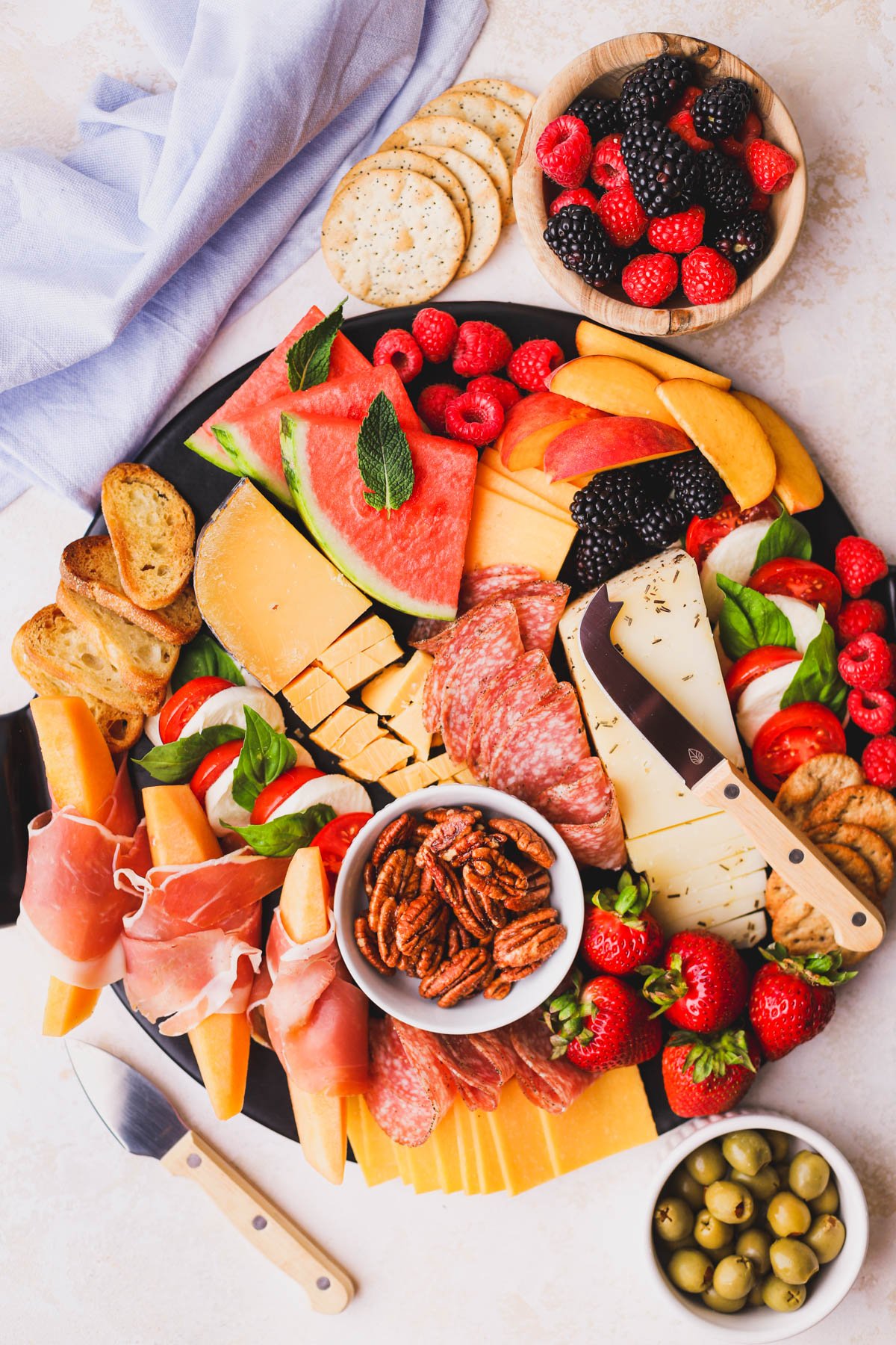 Easy summer charcuterie board filled with a variety of cheeses, meats, fruits and crackers.