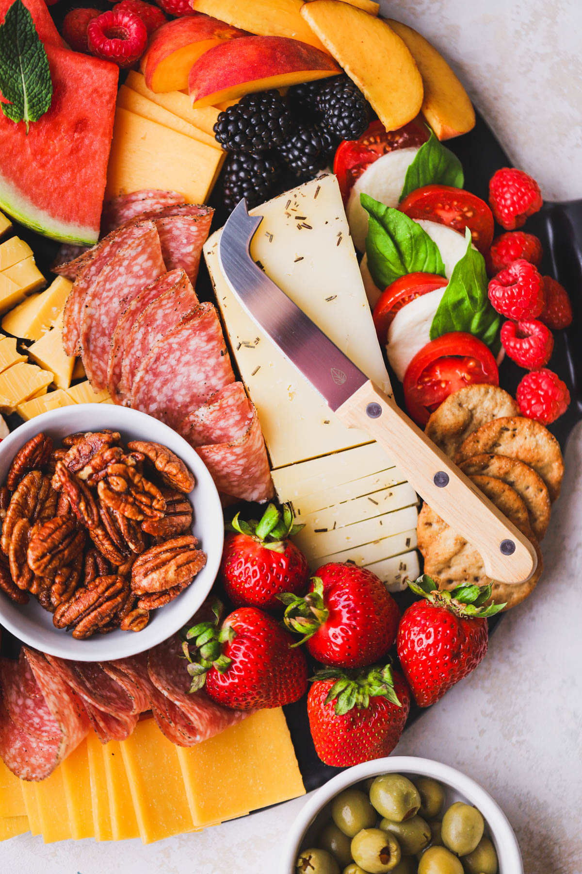 The ultimate summer charcuterie board filled with season fruits, cheese, meat and crackers.  