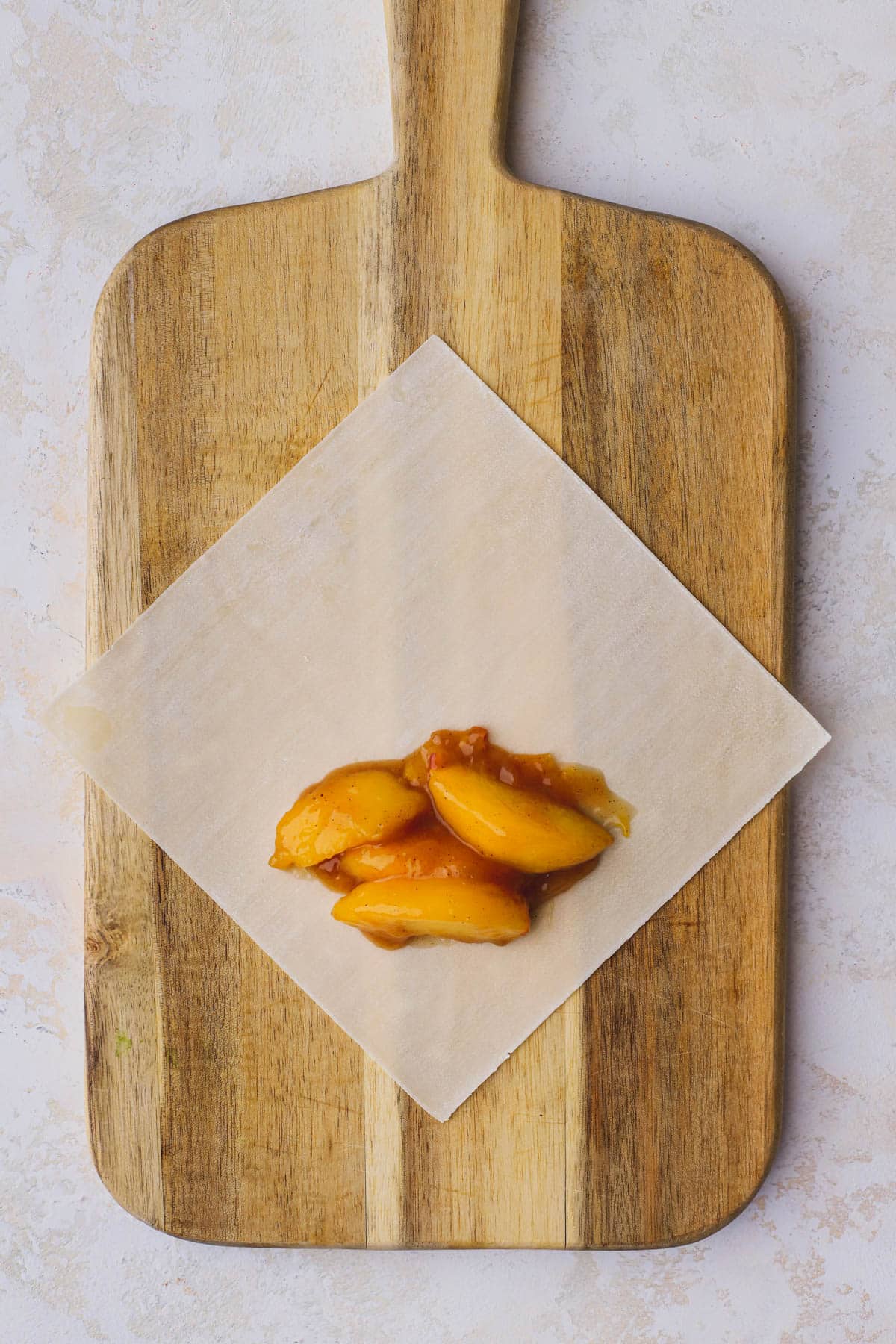 Egg roll skin filled with peach cobbler filling.