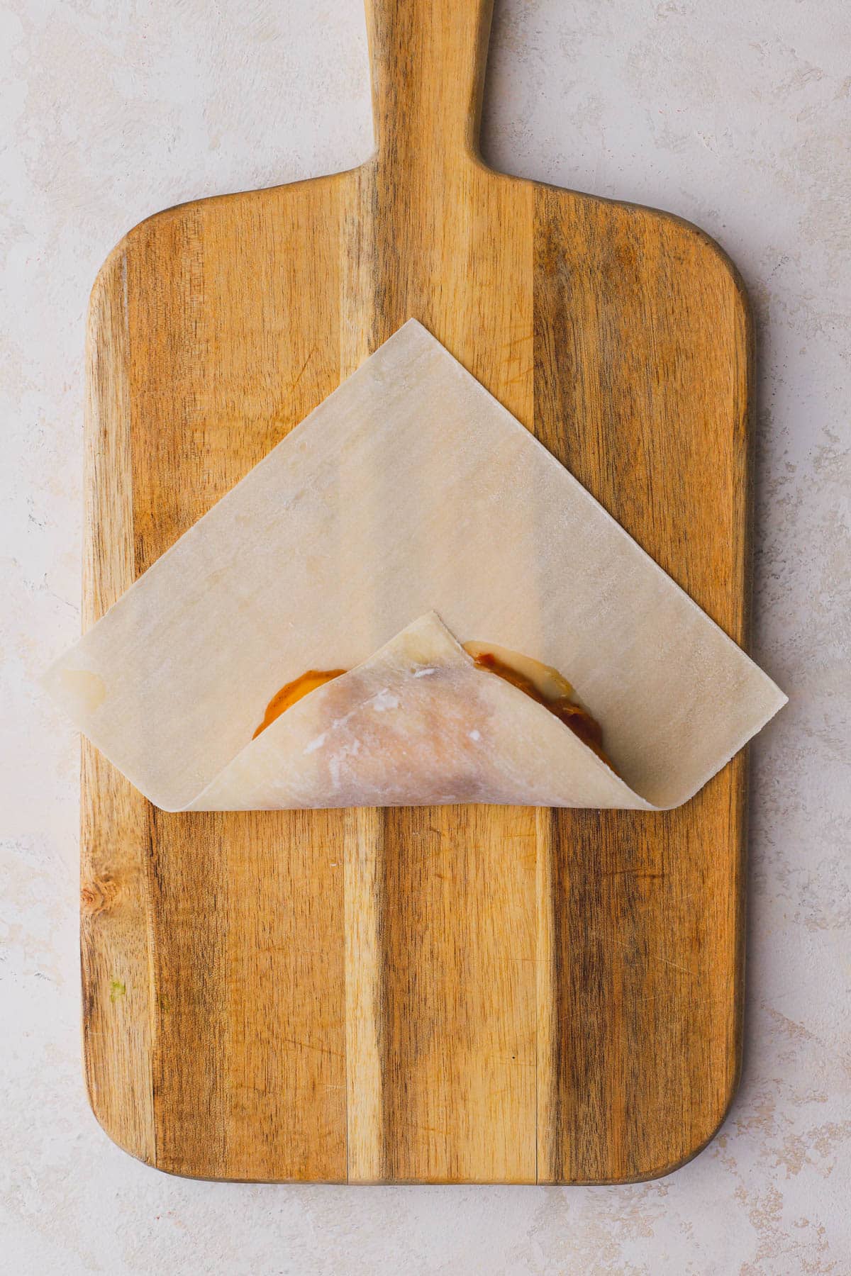 Egg roll skin with peach filling rolled to the center.