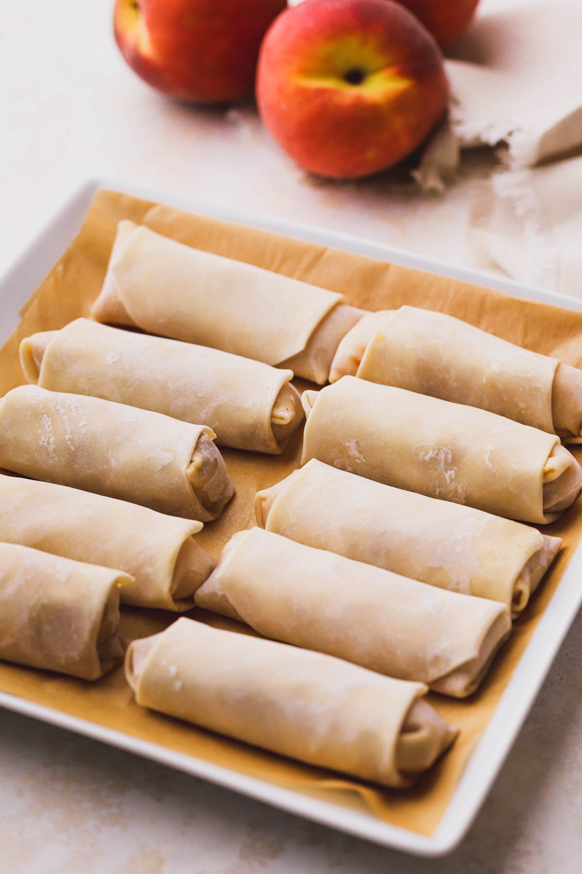Tray of peach egg rolls, ready to deep fry.