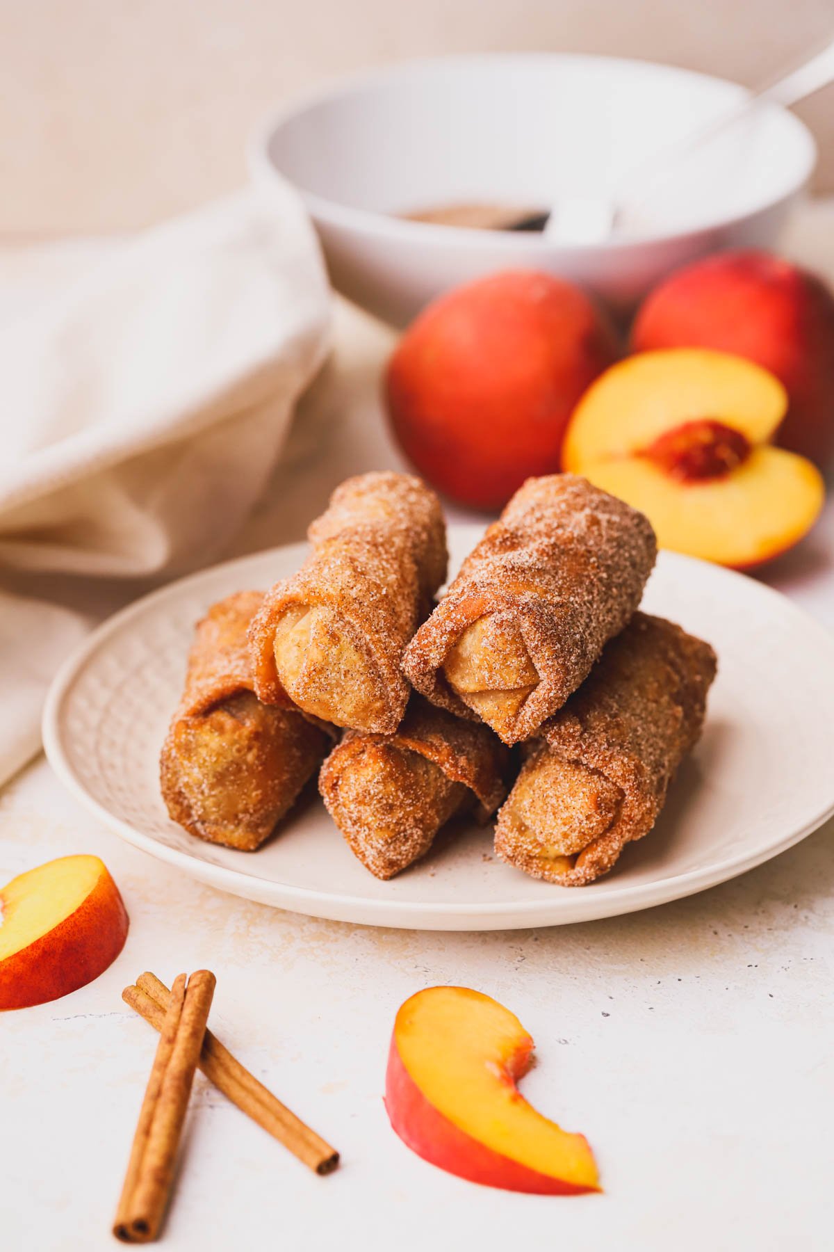 Deep fried peach cobbler egg rolls covered in cinnamon sugar.
