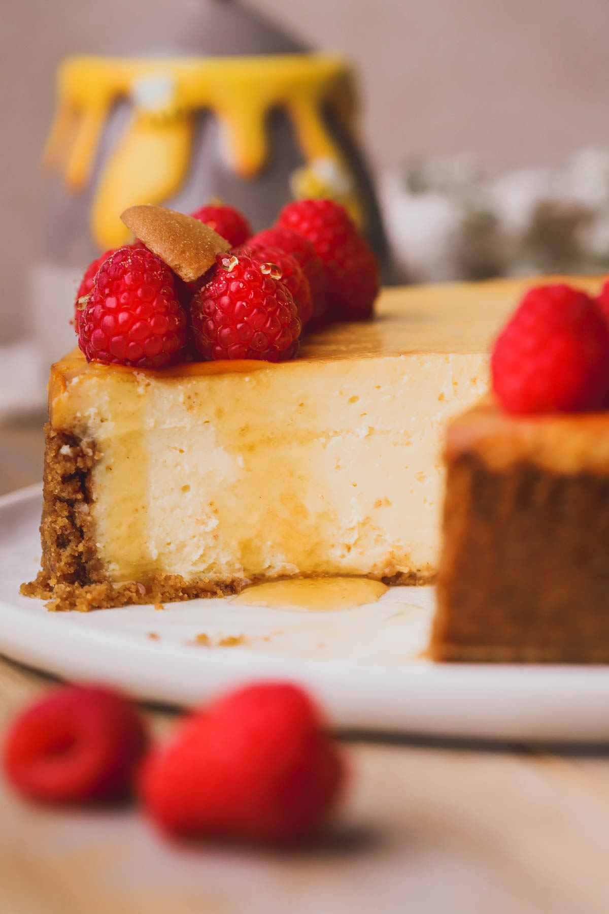 Creamy baked cheesecake with a raspberries and a drizzle of honey.