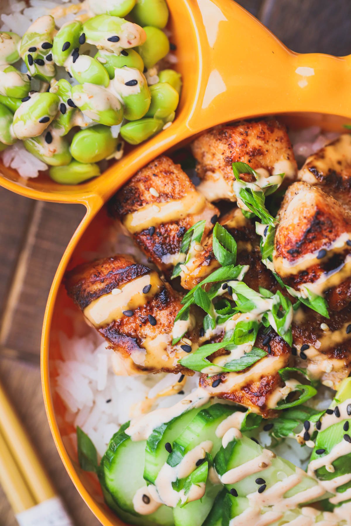 Spicy salmon bowl filled with crispy chunks of salmon, edamame, rice, green onions and spicy mayo.