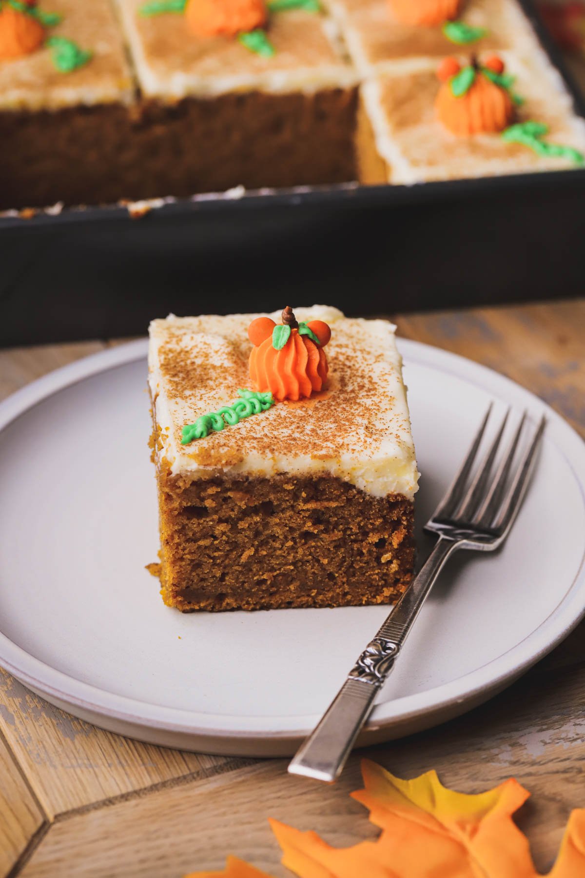 Moist pumpkin bread with cream cheese frosting decorated with piped Mickey pumpkins.