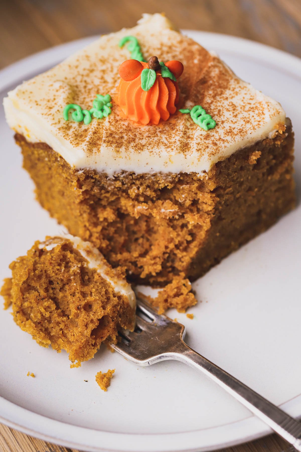 Moist pumpkin cake smothered with cream cheese frosting and piped buttercream pumpkins in the shape of Mickey.