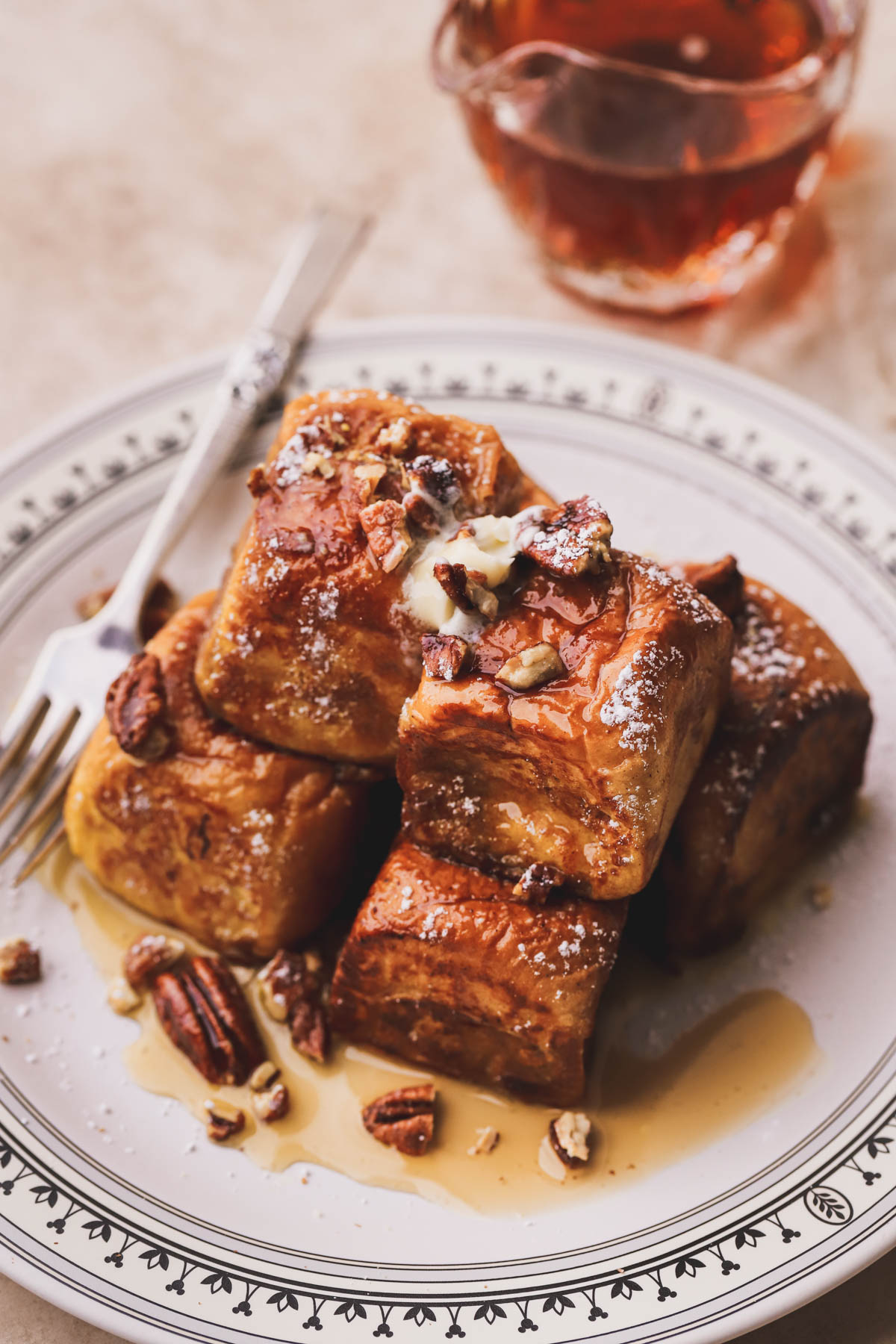 Hawaiian bread French toast flavored with pumpkin spice and drizzled with maple syrup, butter and chopped candied pecans.  