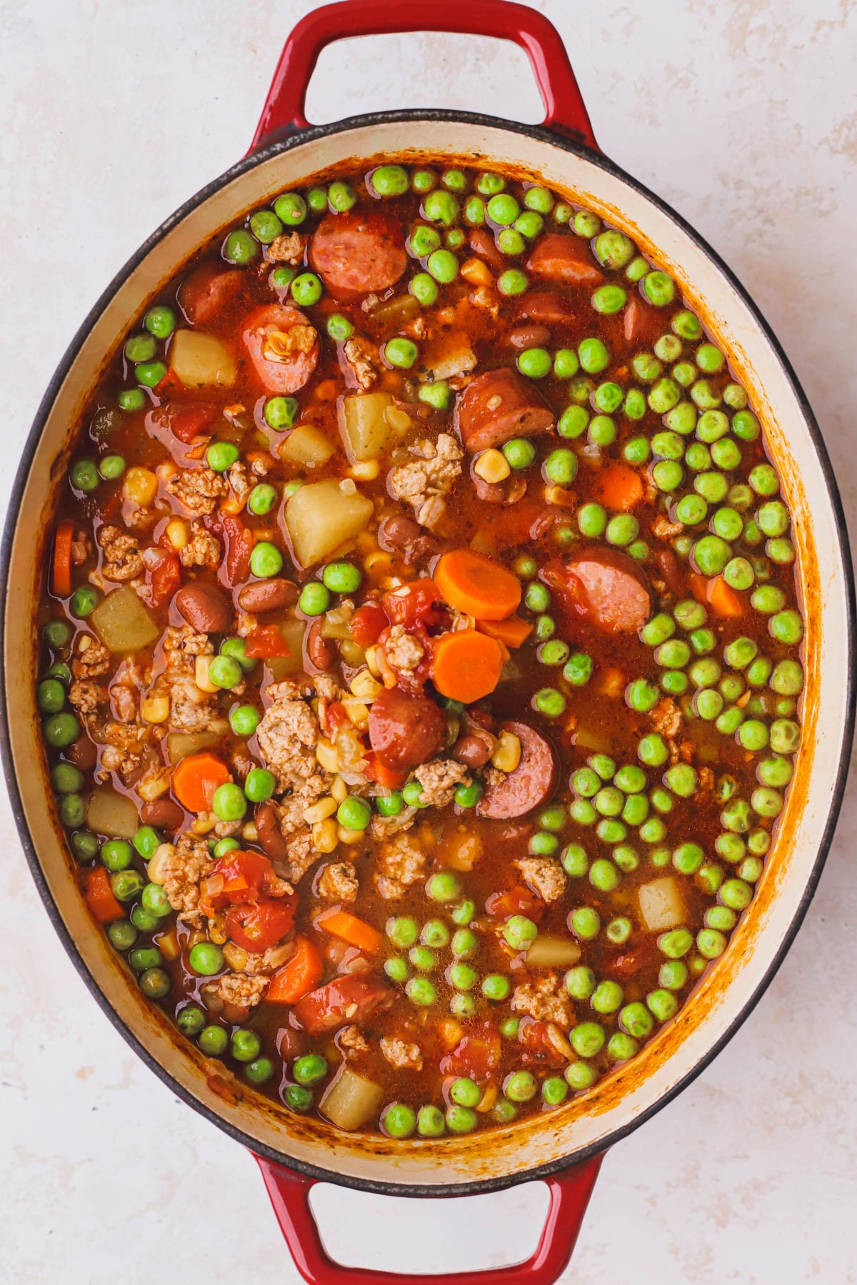 Stewed cowboy soup with ground turkey, sausage, peas, potatoes and tomato broth.