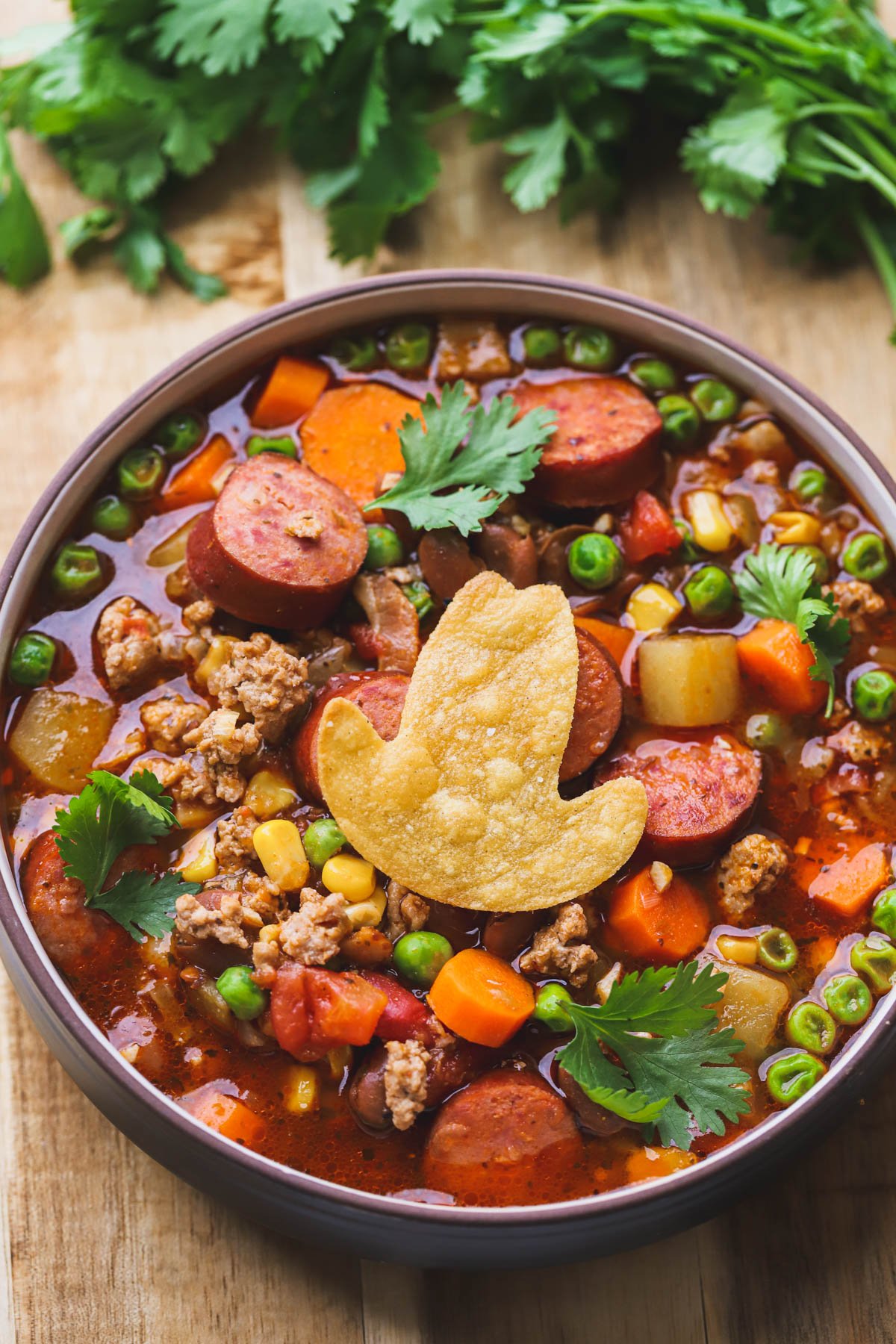Ground turkey, sausage, chunks of vegetables and potatoes, corn, beans, tomato broth. Cowboy hat tortilla chip.
