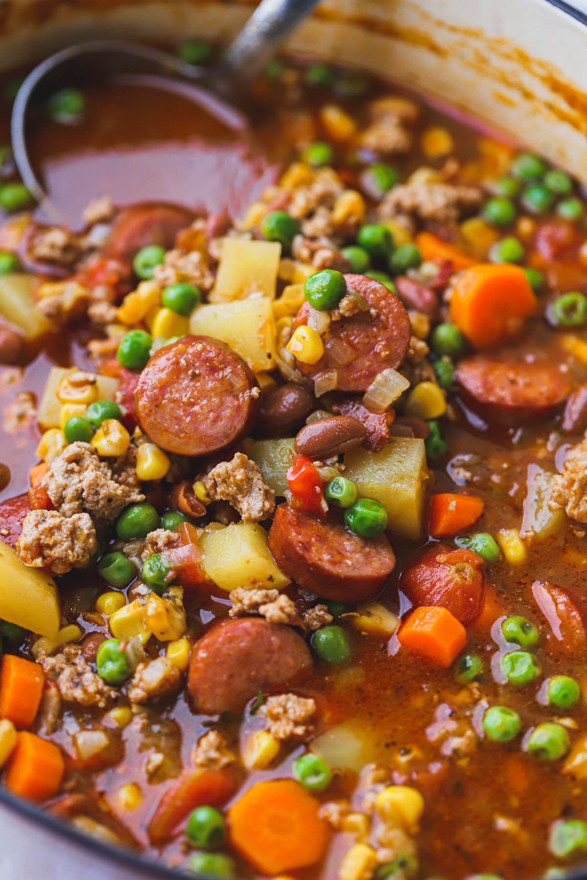 Cowboy soup made with chunks of vegetables, sausage bacon and beans.