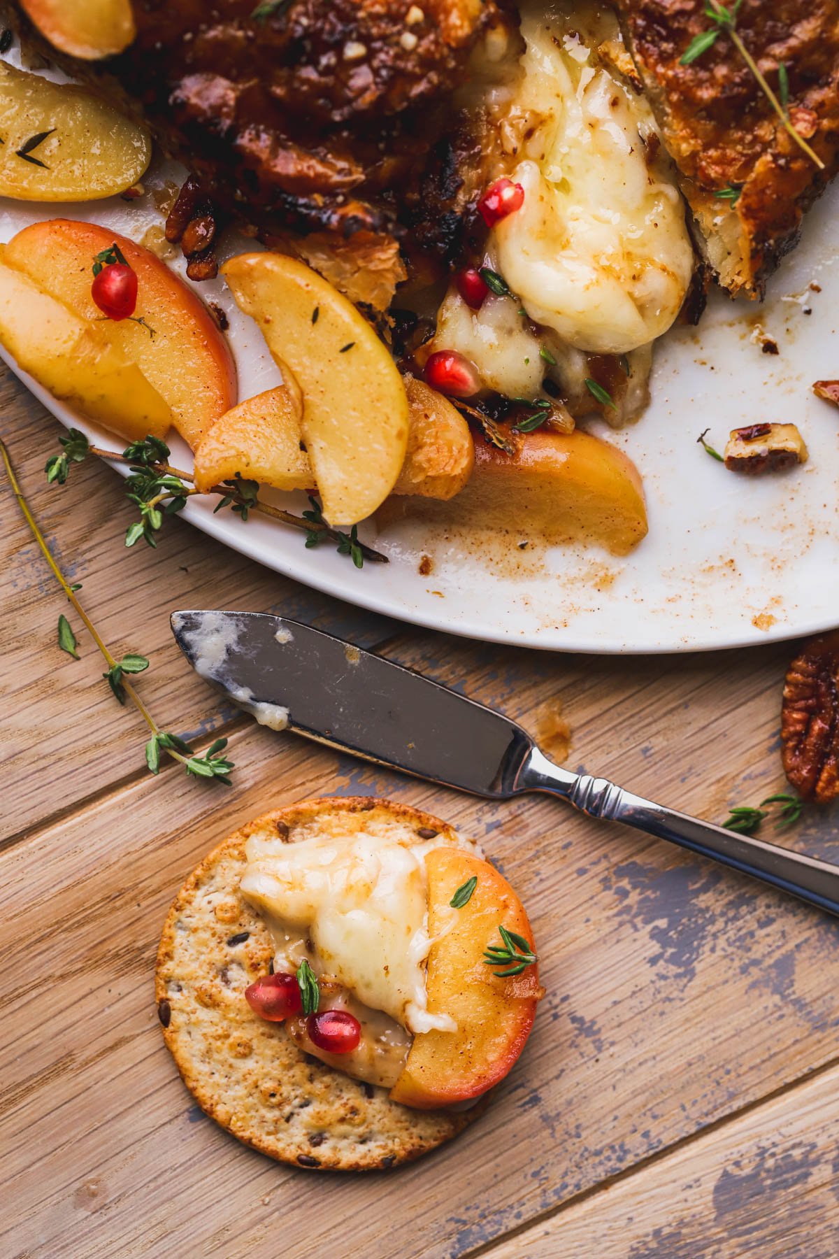 Baked brie with fig jam spread on top of cracker.