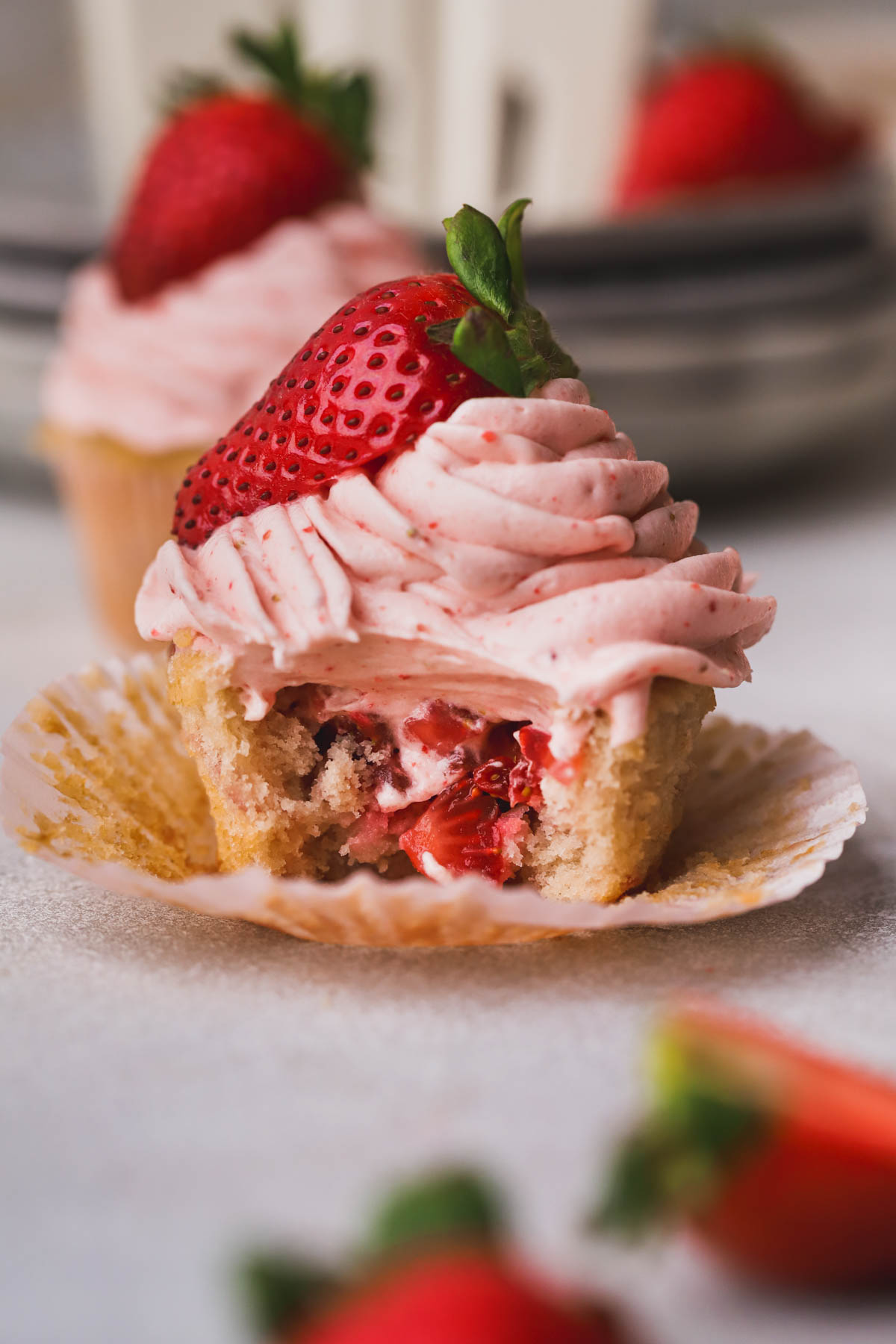 Strawberry filled cupcakes with strawberry cream cheese frosting and diced strawberries inside.  