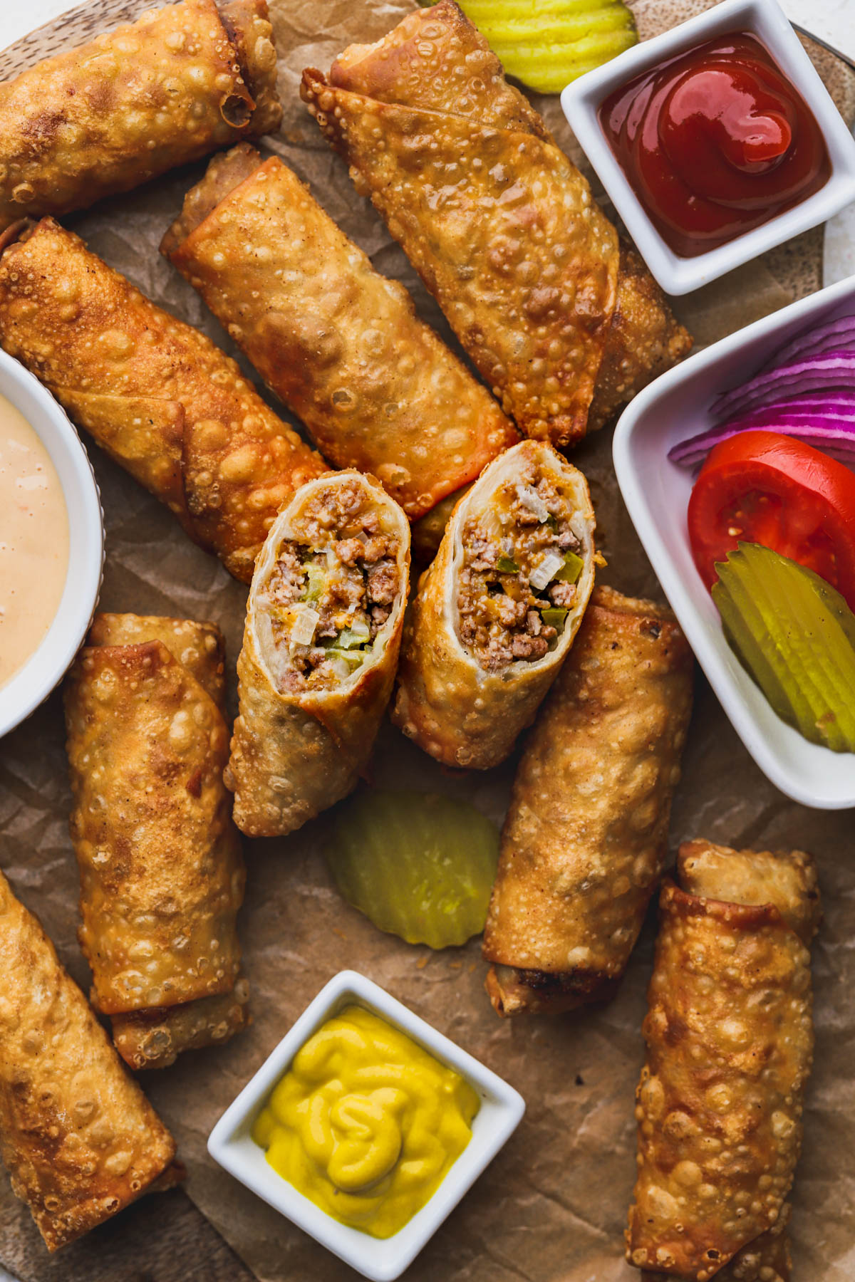 Egg rolls filled with ground beef, pickles, onions and cheese.  