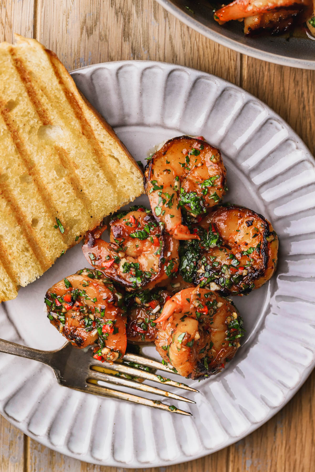 Seared shrimp tossed with chimichurri sauce and grilled bread.  