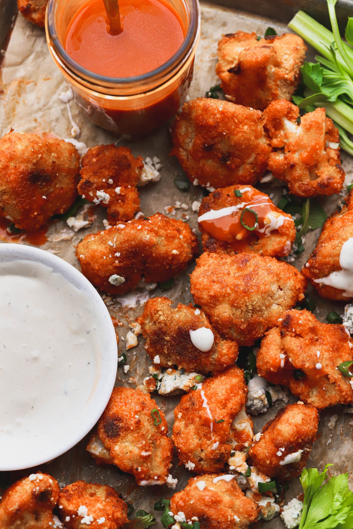 buffalo crispy cauliflower bites topped with ranch dressing and blue cheese.