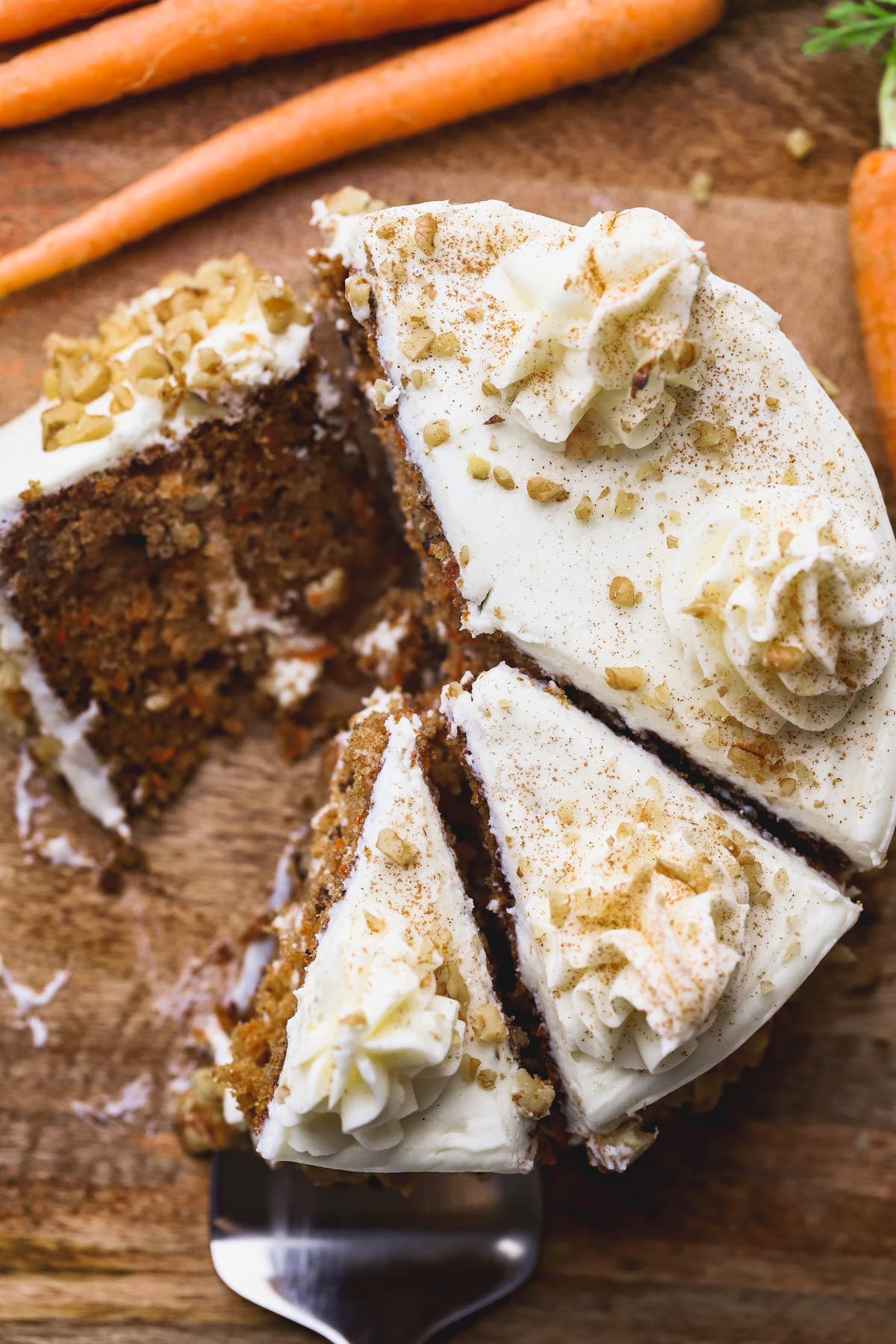Cream cheese covered carrot cake with chopped walnuts.  