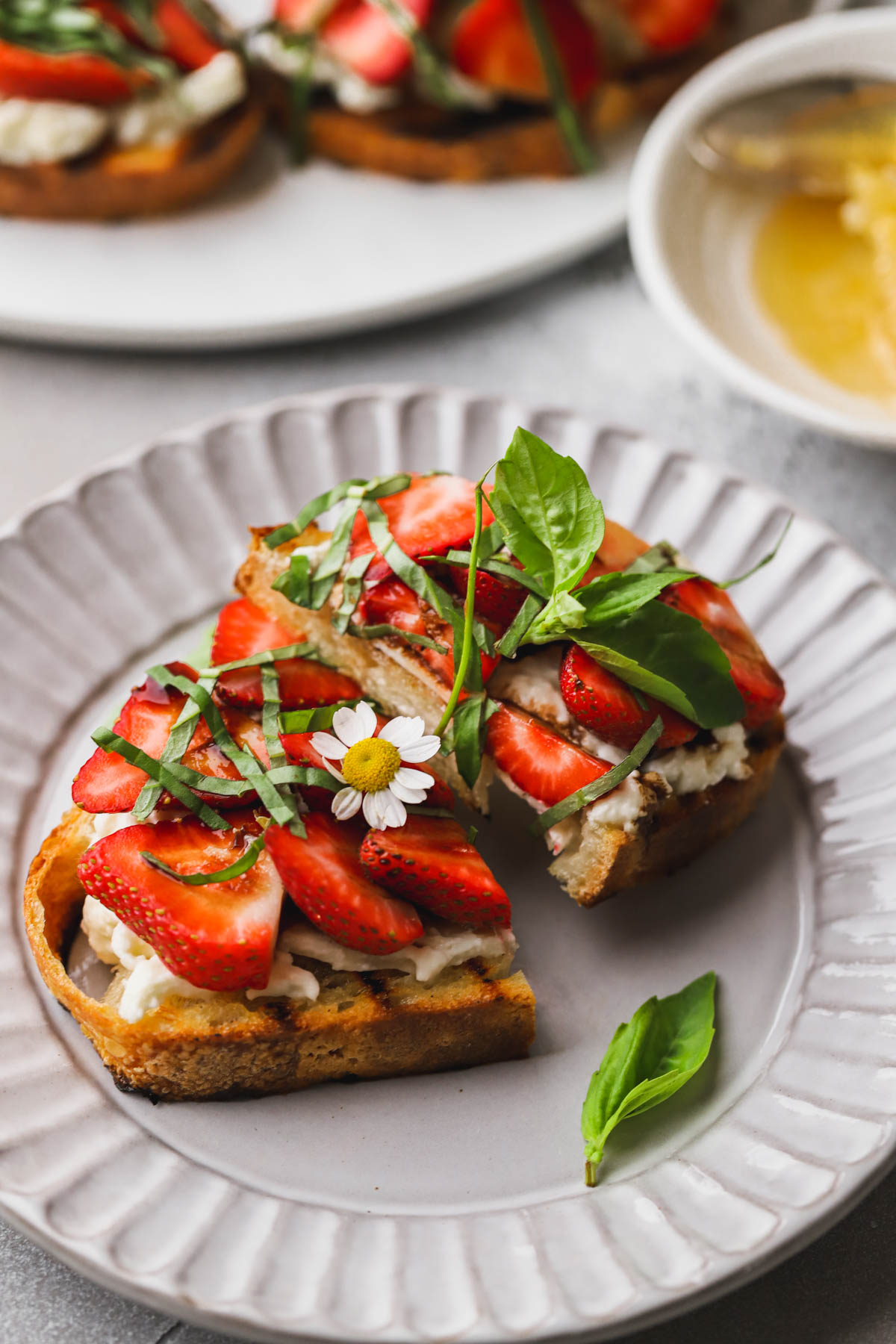 Strawberry burrata bruschetta with grilled bread, sliced strawberries, fresh basil and balsamic reduction. 
