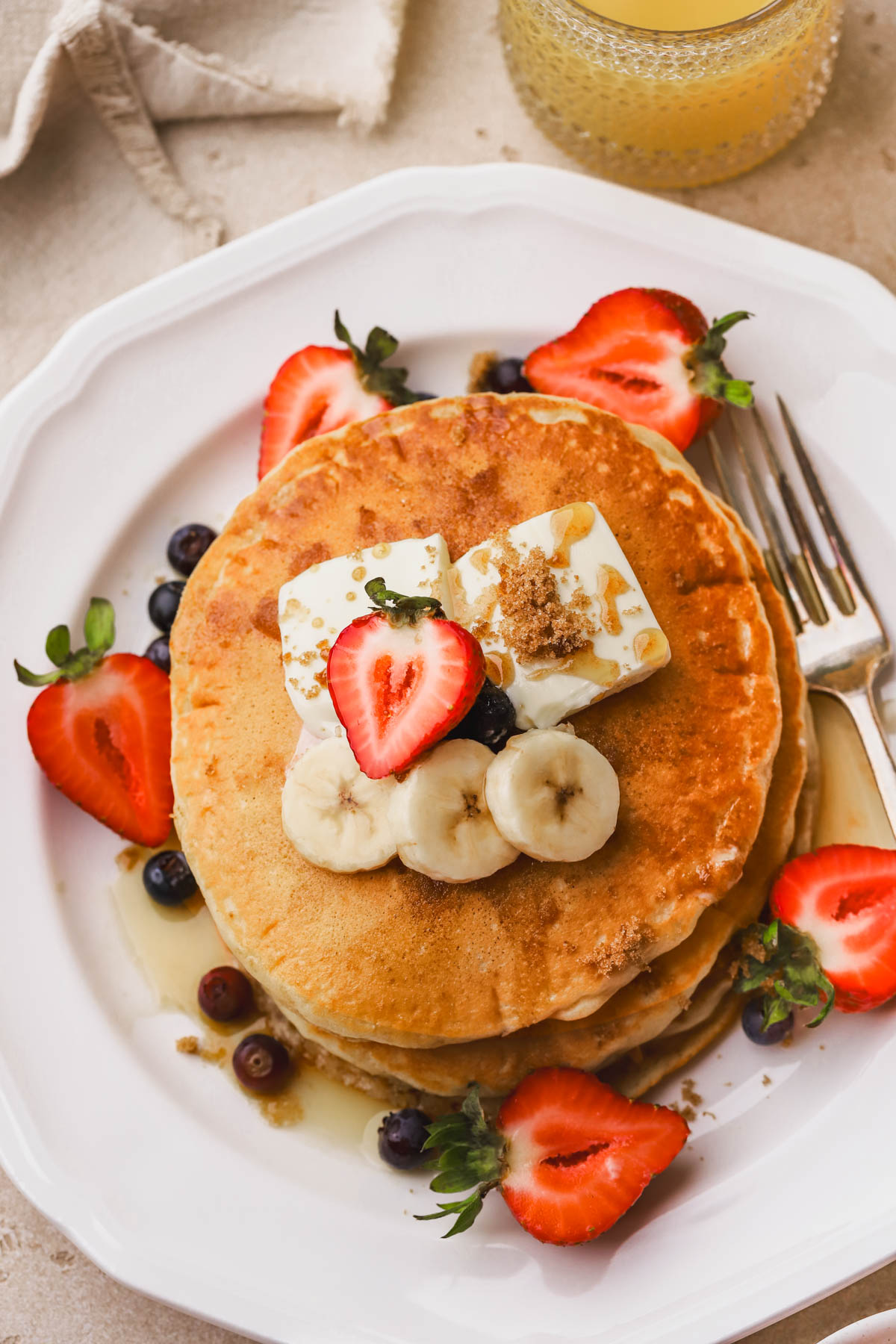 Pancakes with brown sugar, bananas, berries, butter and maple syrup. 