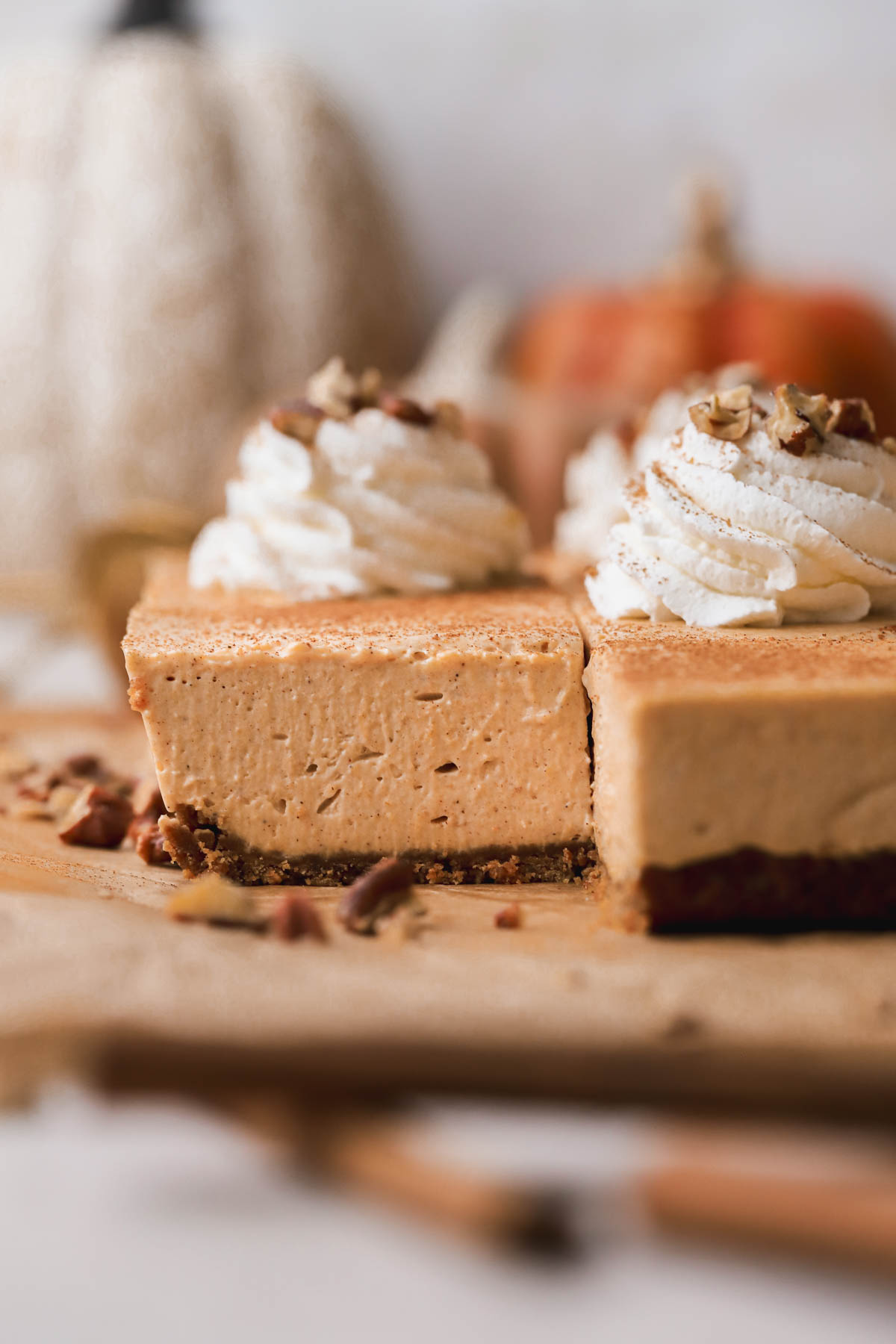 No bake pumpkin cheesecake bars, topped with homemade whipped cream cinnamon and candied pecans.  