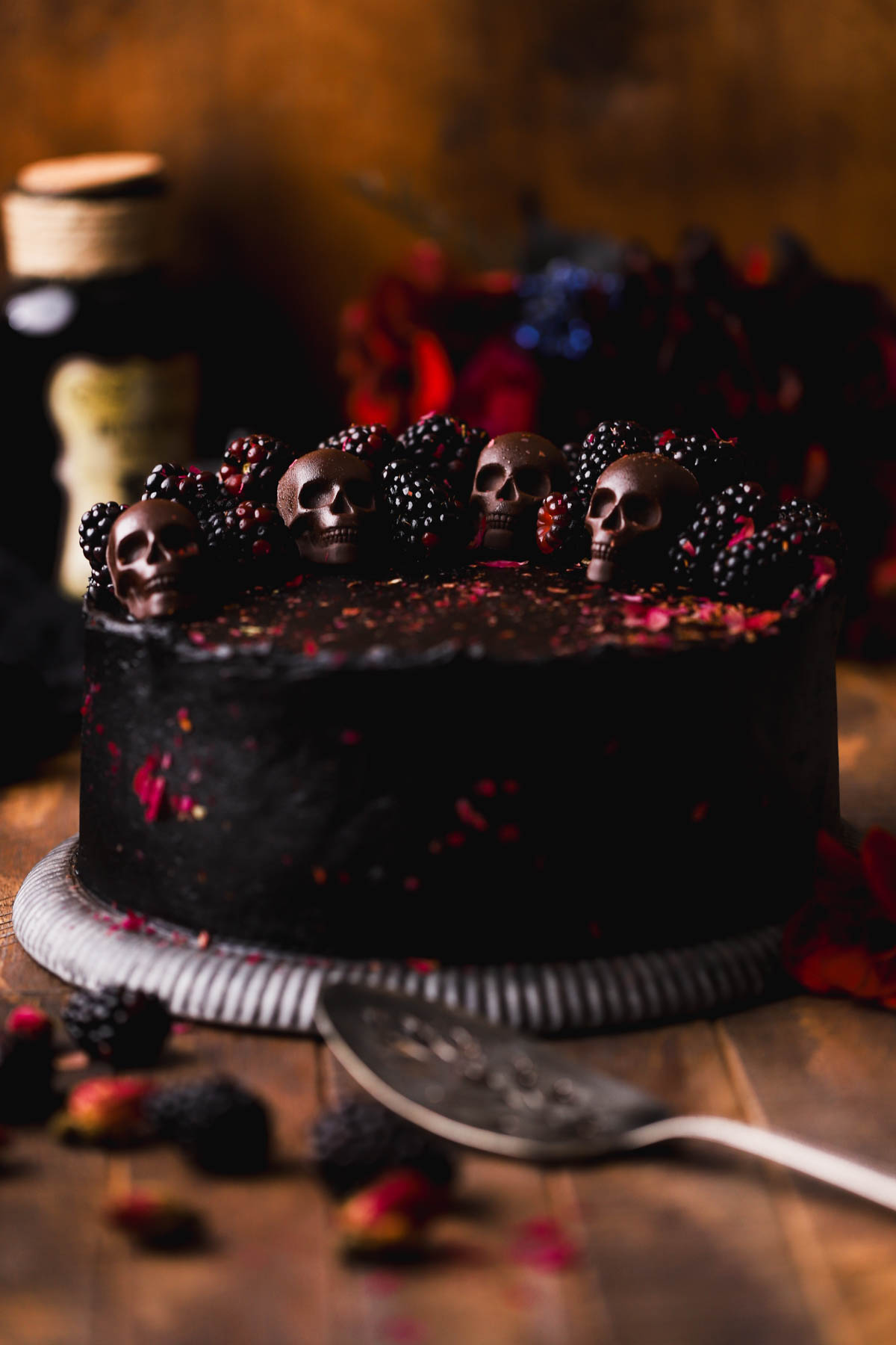 Frosted black velvet cake with chocolate skulls and fresh blackberries.  