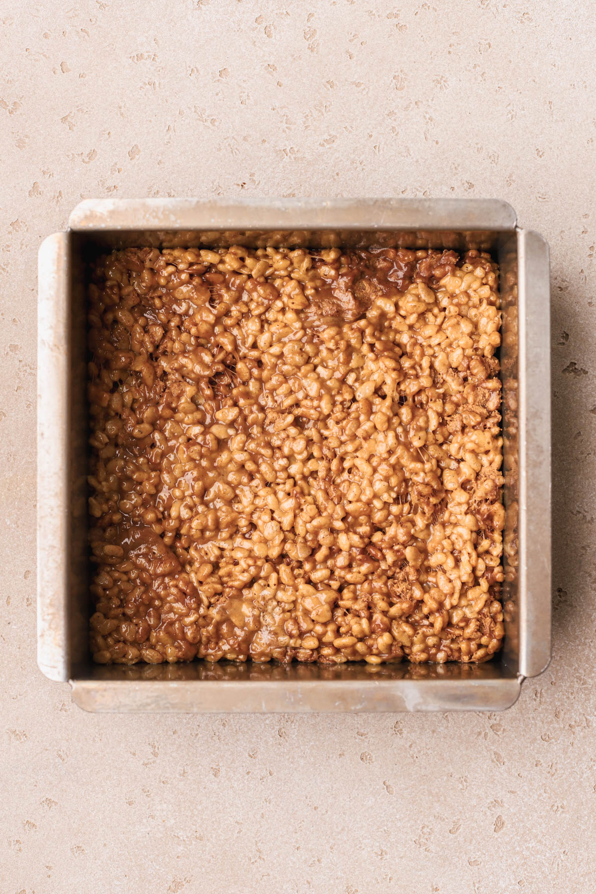 Peanut butter Rice Krispies with Reese's peanut butter cups inside baking pan. 