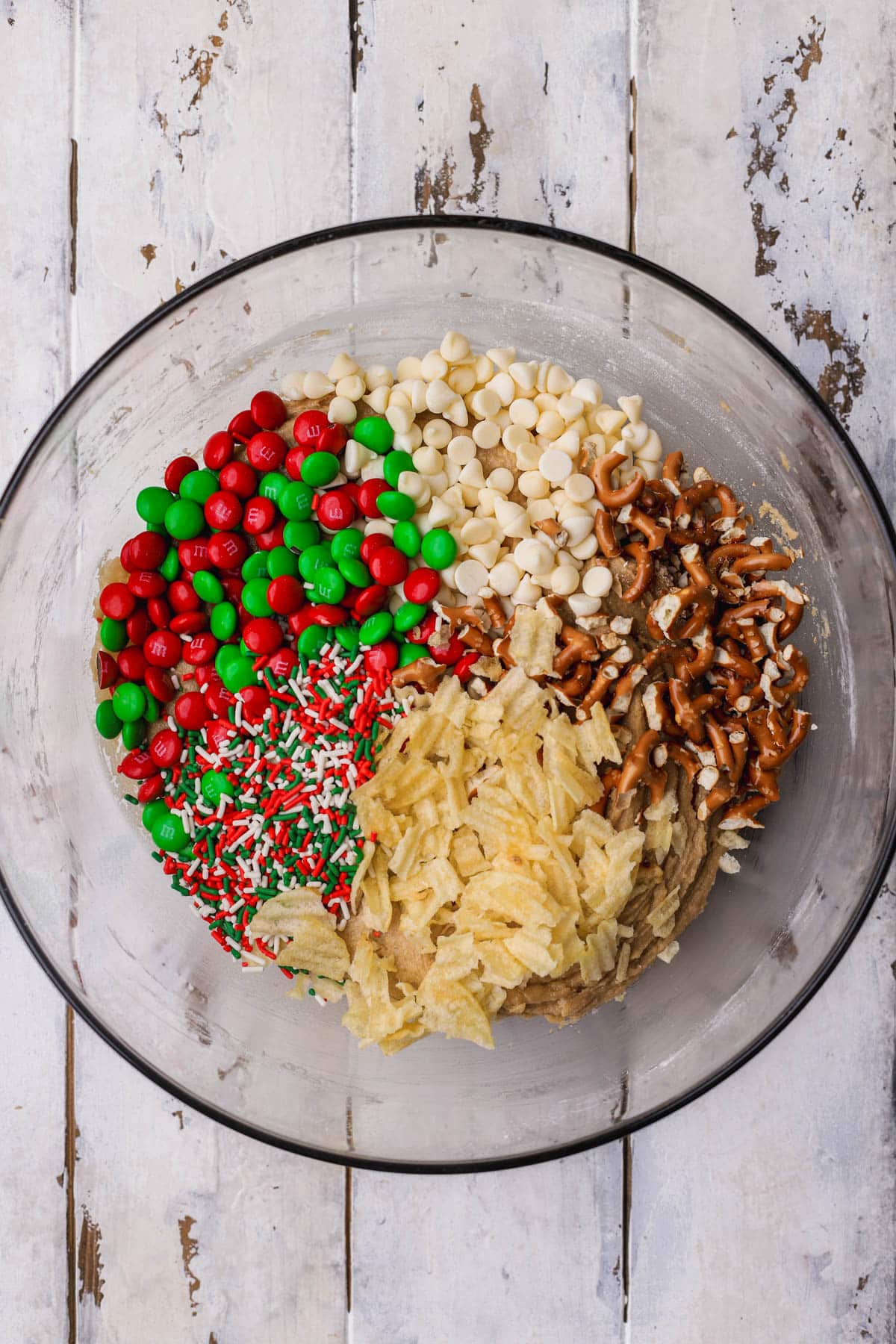Cookie dough with M&M's, white chocolate chips, pretzels, potato chips and Christmas jimmies. 