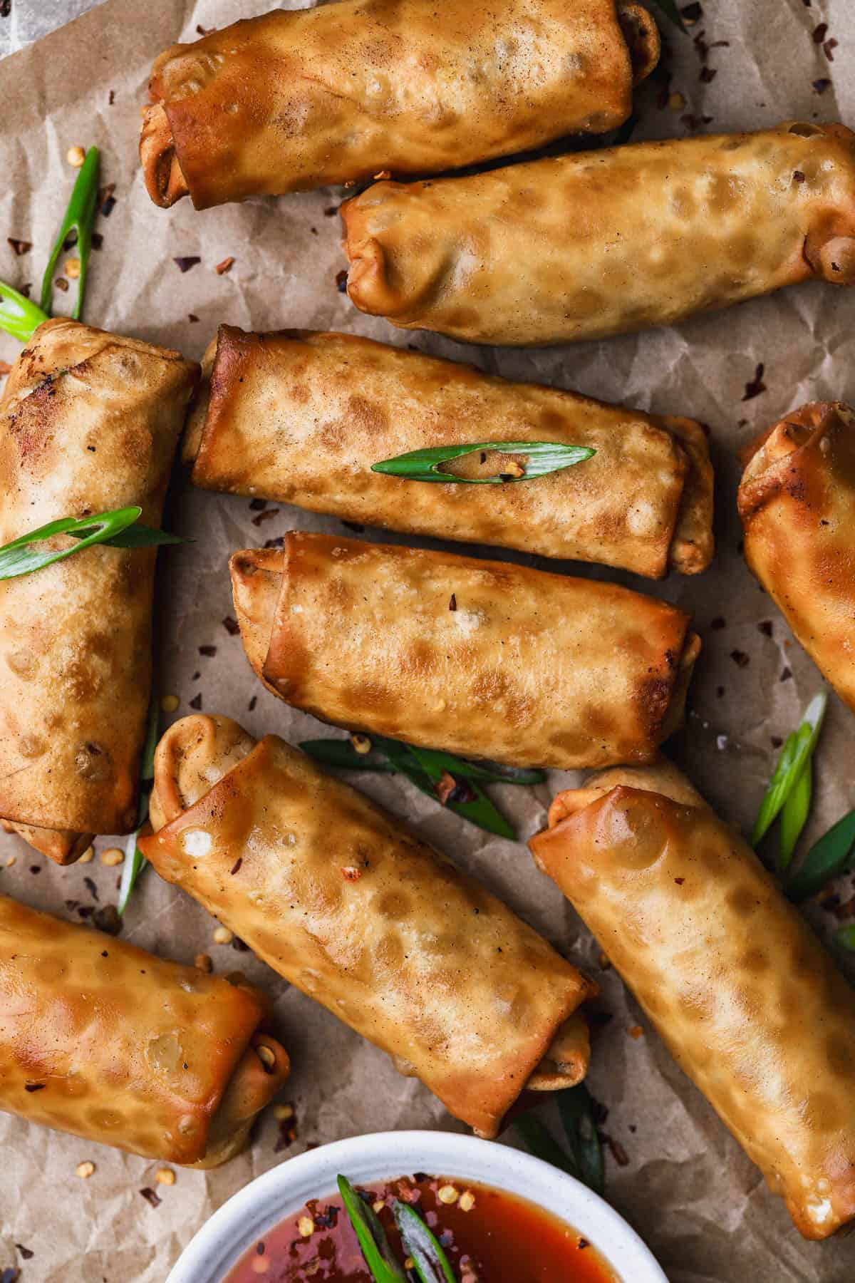 Crab rangoon egg rolls with sliced scallions. 