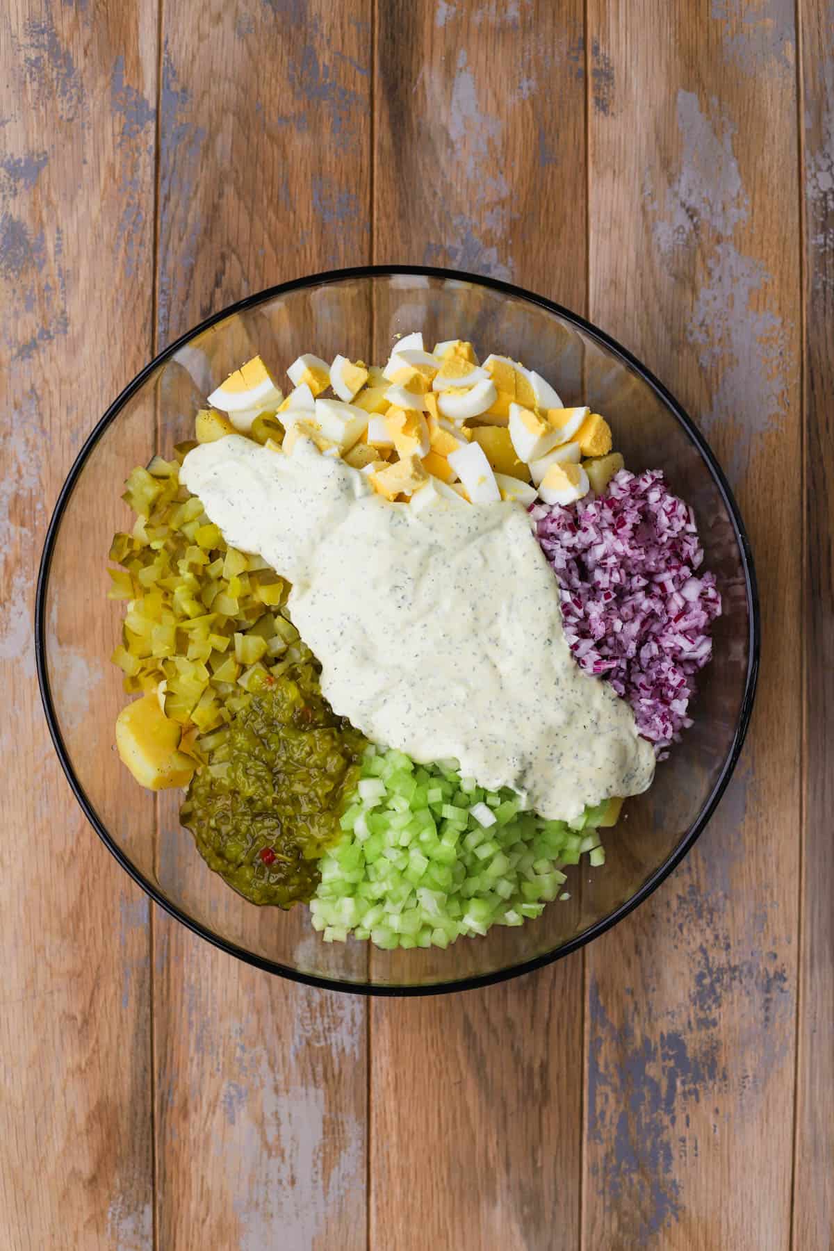 Gold potatoes, onions, hard boiled eggs, relish, pickles, celery and dressing. 