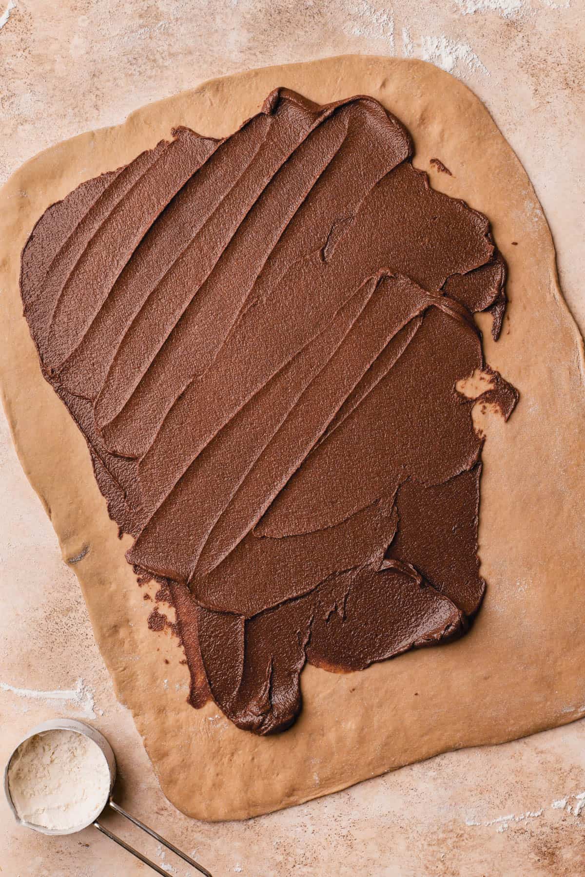 Cinnamon filling spread over dough.