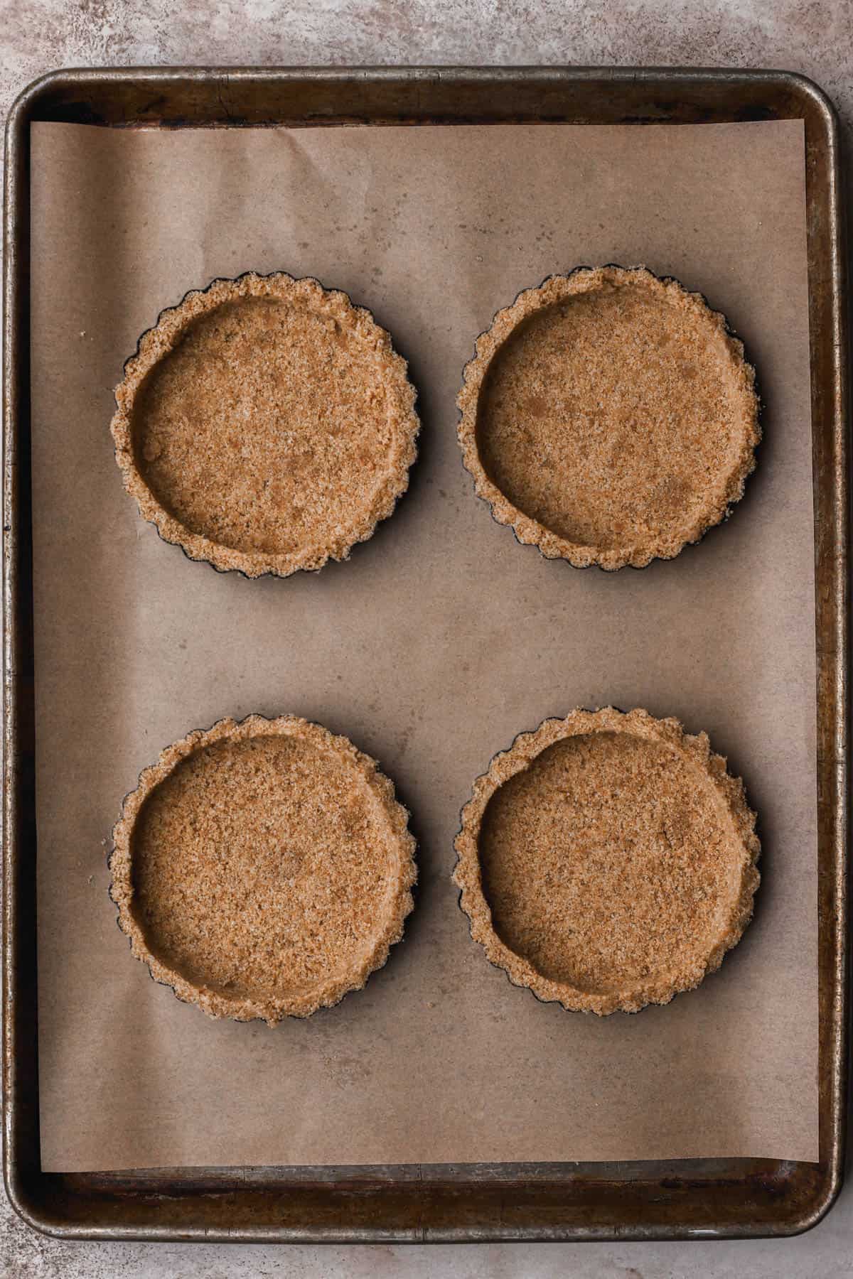 Graham cracker crust pressed into tart molds.