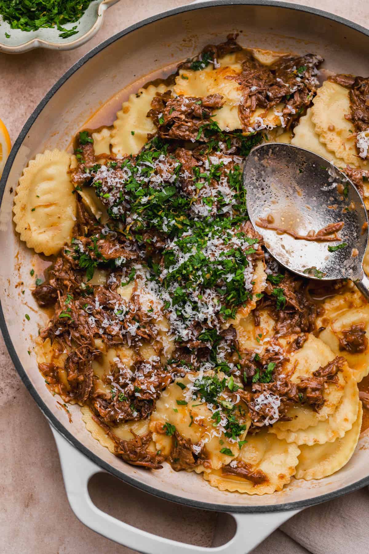 Short rib ravioli with gremolata and grated parmesan cheese.