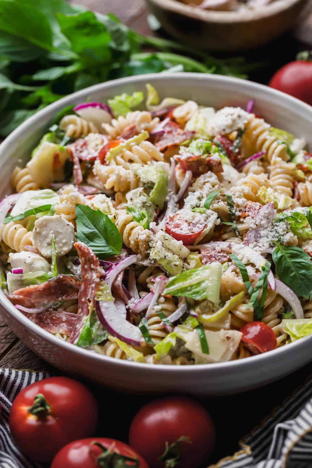 Grinder pasta salad with creamy dressing, cured meats, mozzarella, provolone, romaine lettuce, parmesan, tomatoes and red onions, and pepperoncini.