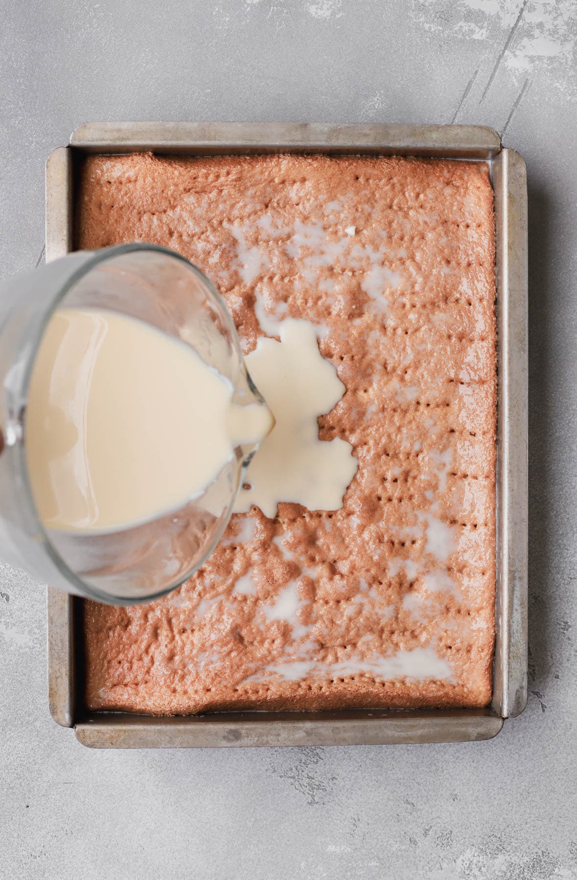 Condensed milk, evaporated, and heavy cream poured over cake.