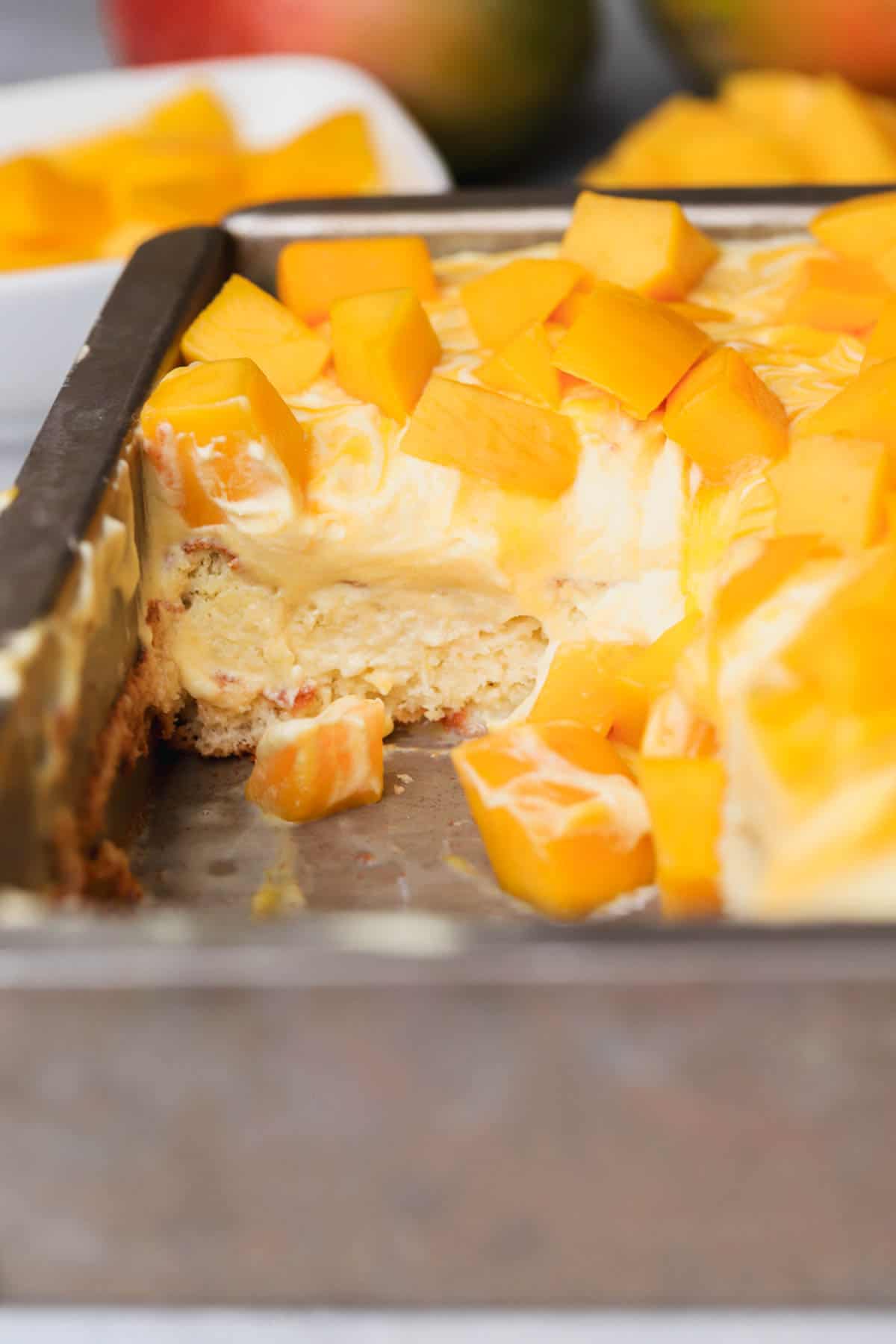 Mango Tres Leches cake with chunks of fresh mango and whipped cream.