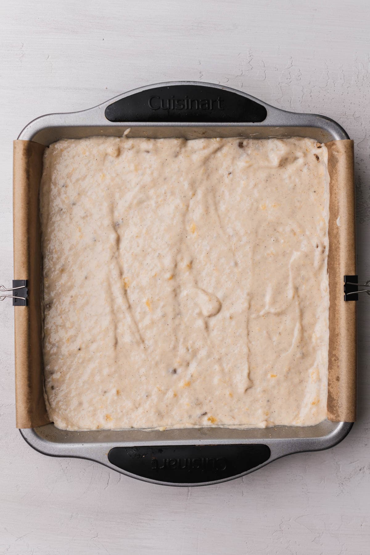 Banana bread batter inside a 9x9 cake pan. 
