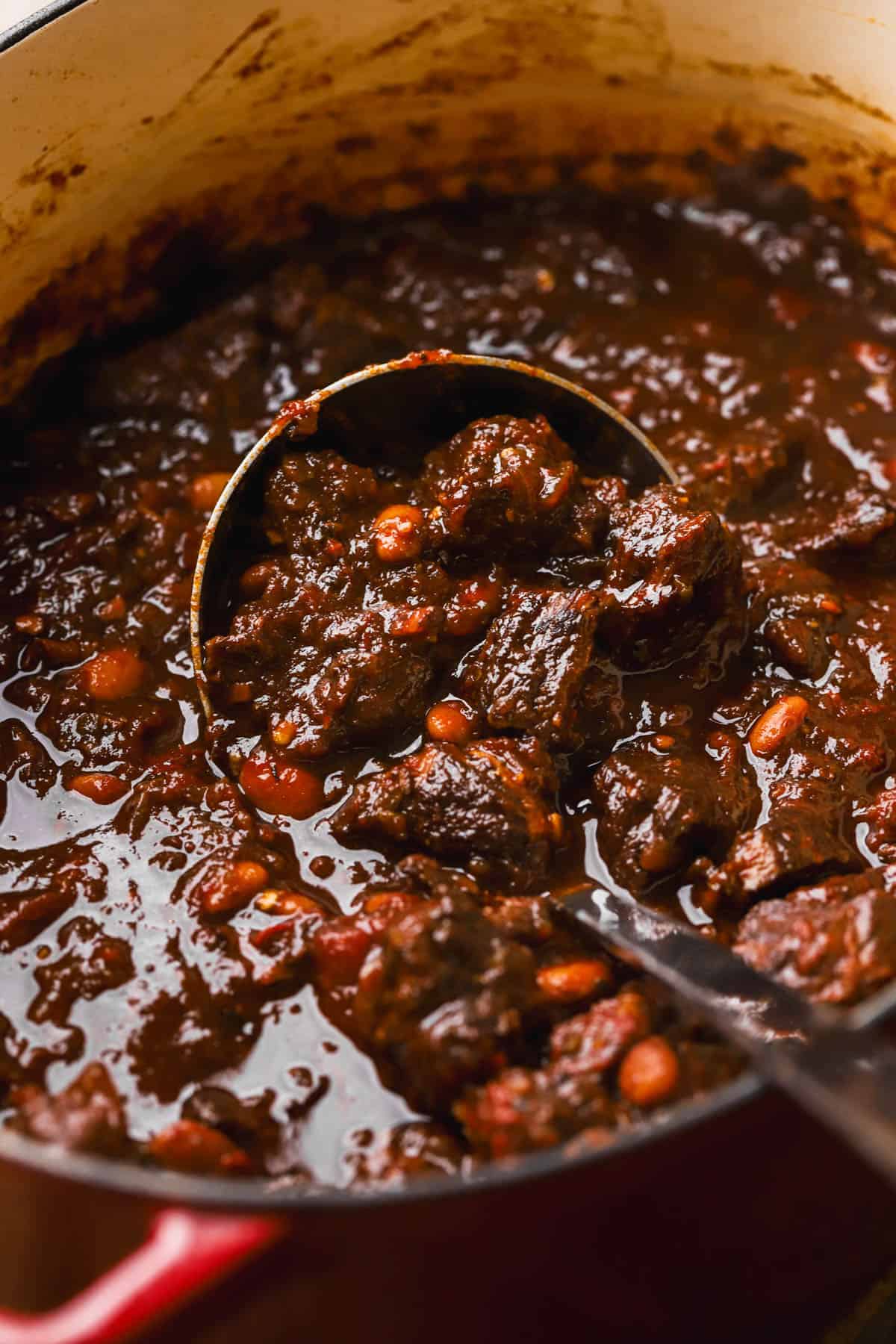 Dutch oven chili con carne with tomatoes, chili sauce and pinto beans. 