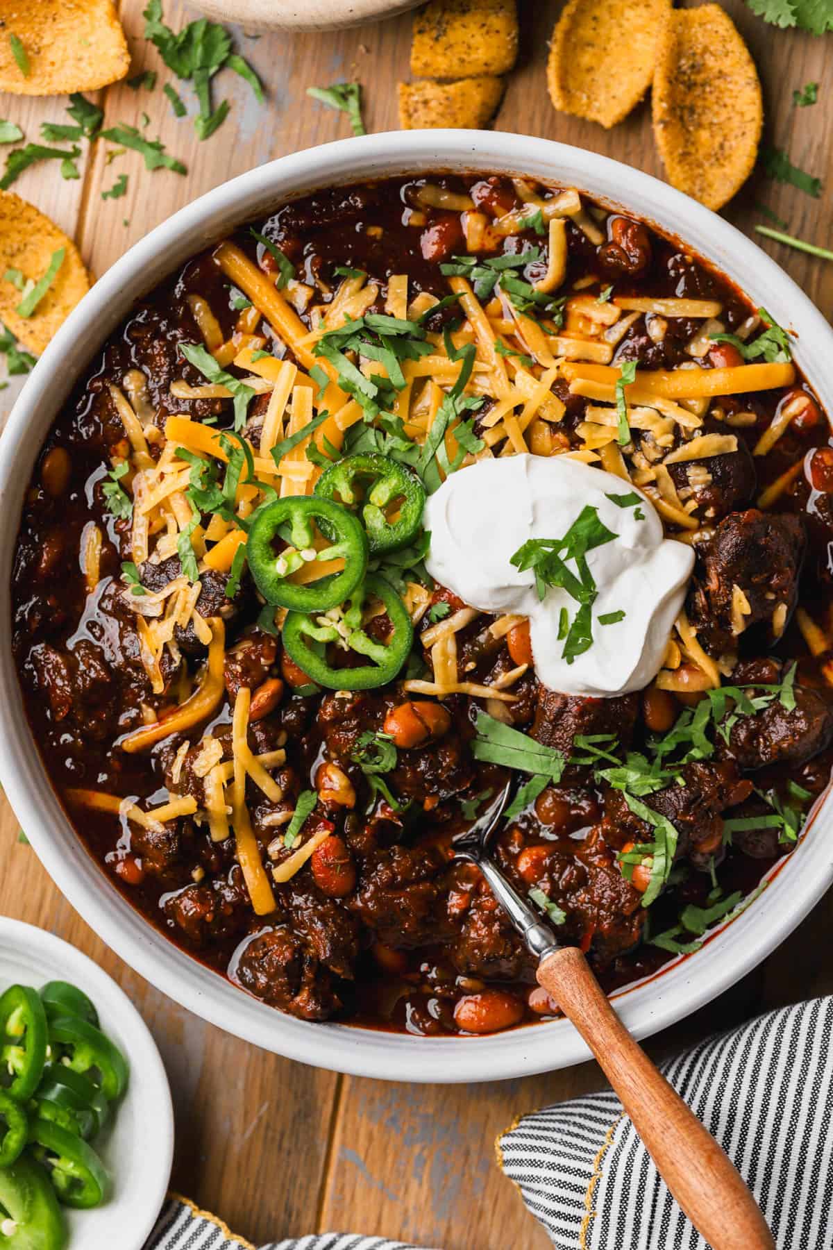 Dutch oven chili con carne with pinto beans, tomatoes, cheese, jalapenos and sour cream. 