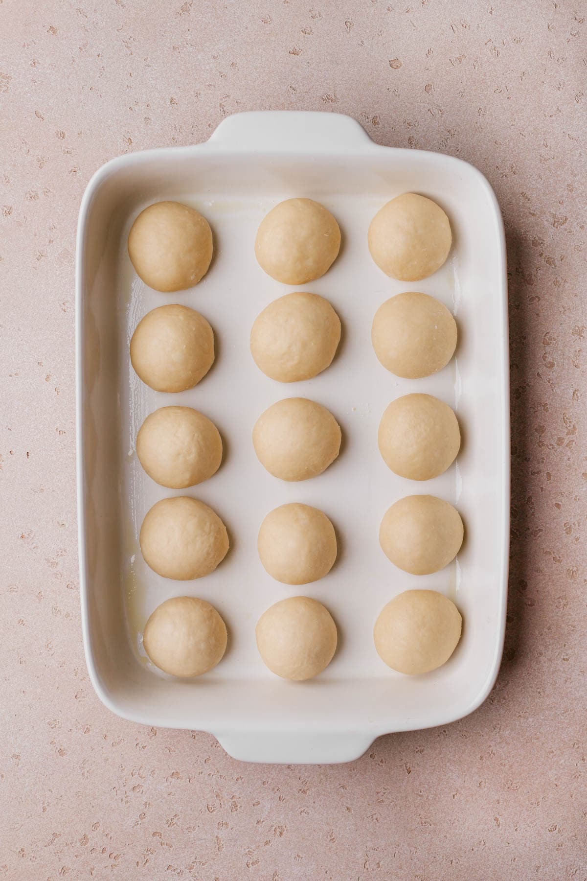 Dough formed into small balls and placed into greased baking dish. 
